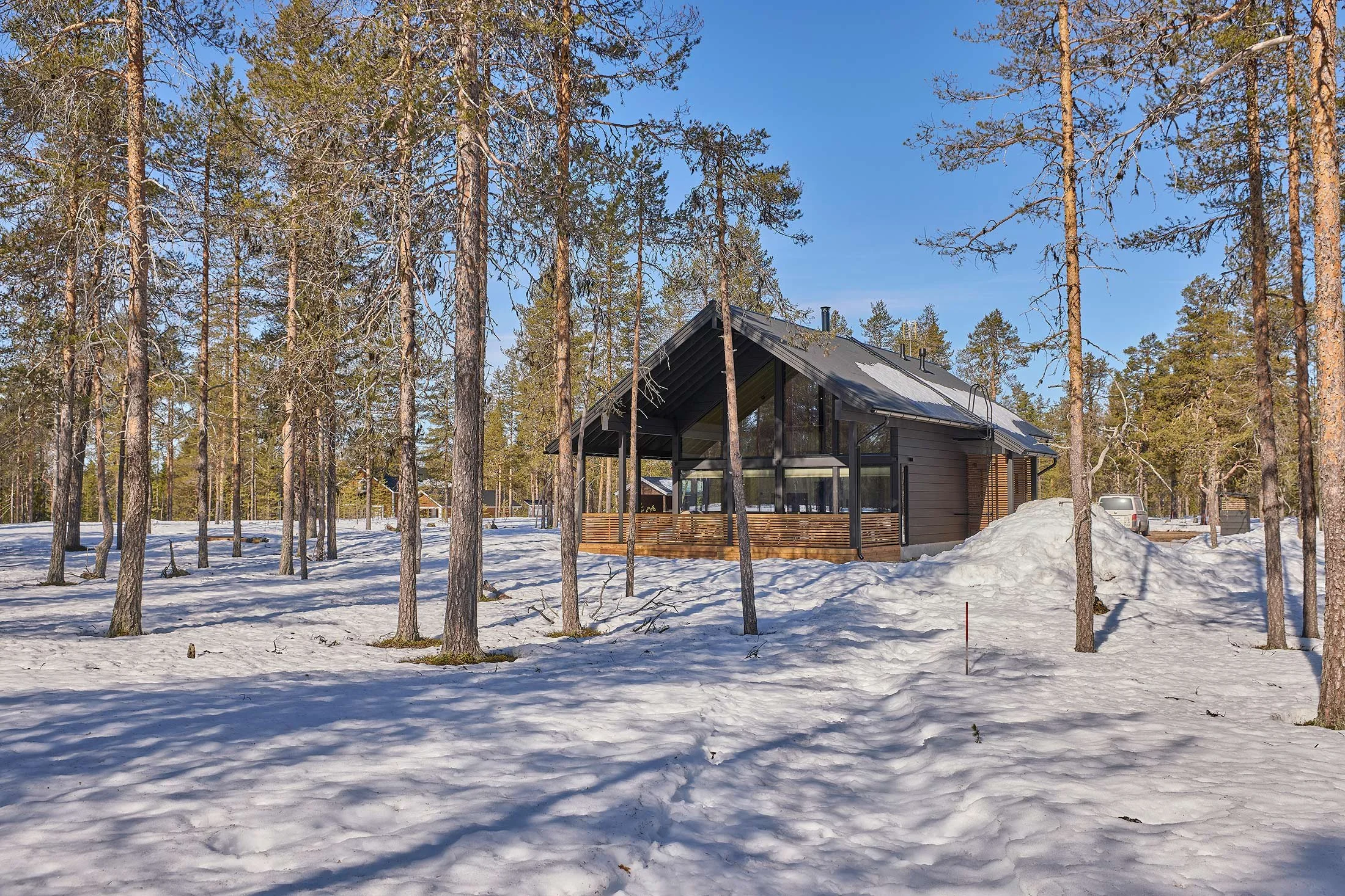 Harjakattoinen tumma hirsimokki Äköslompolossa Yllästunturin juurella.