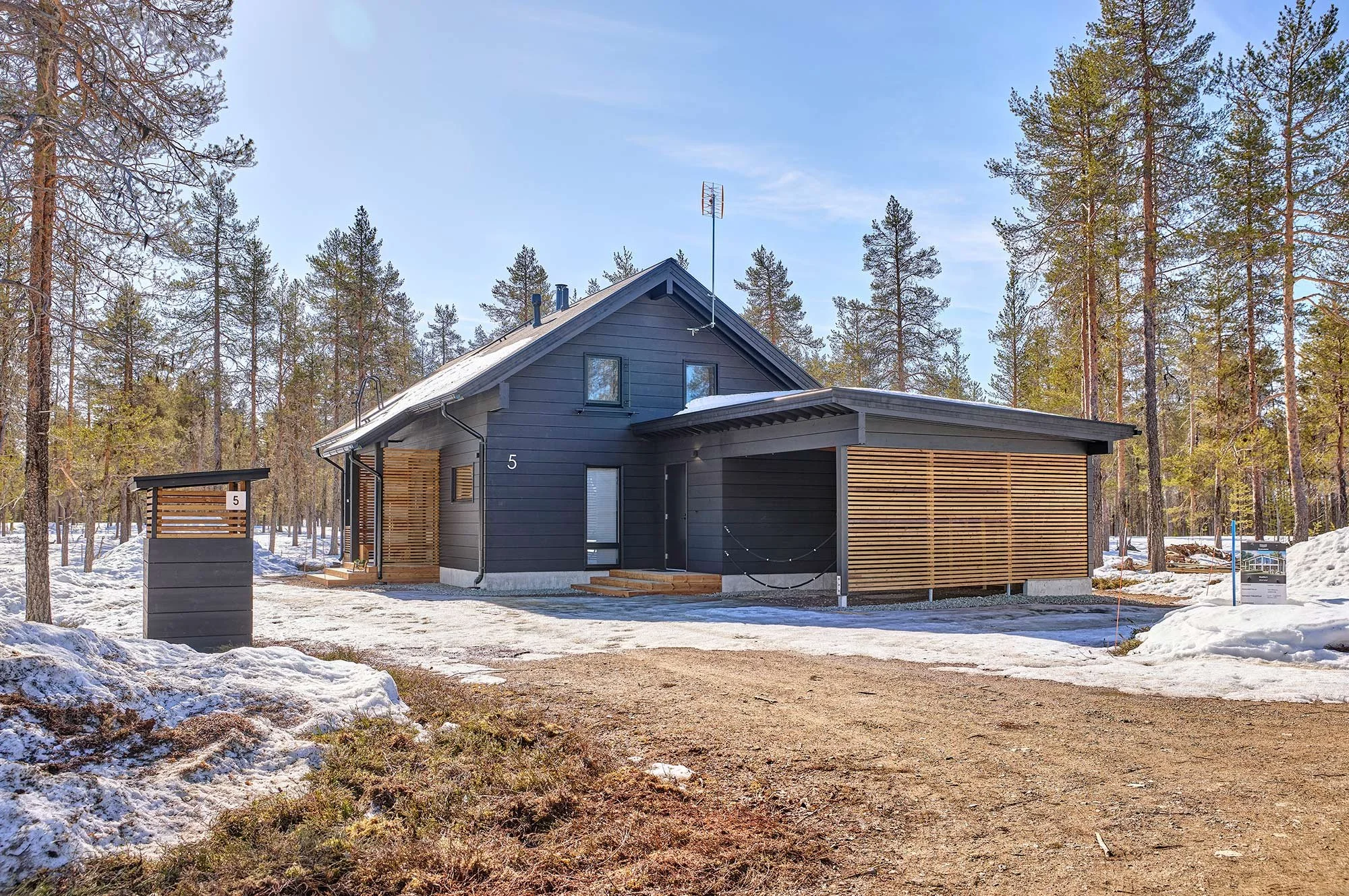 tumma-moderni-harjakattoinen-hirsimokki-yllaksella-lapissa.jpg