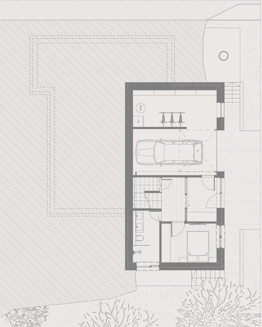 Floor plan of a split-level house with a garage, bedroom, bathroom, and utility area, surrounded by outdoor landscaping.