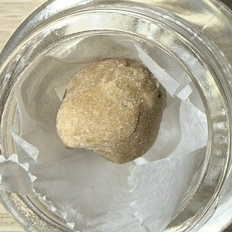 Fresh frozen hash — a pale WPFF bubble hash ball in a glass jar