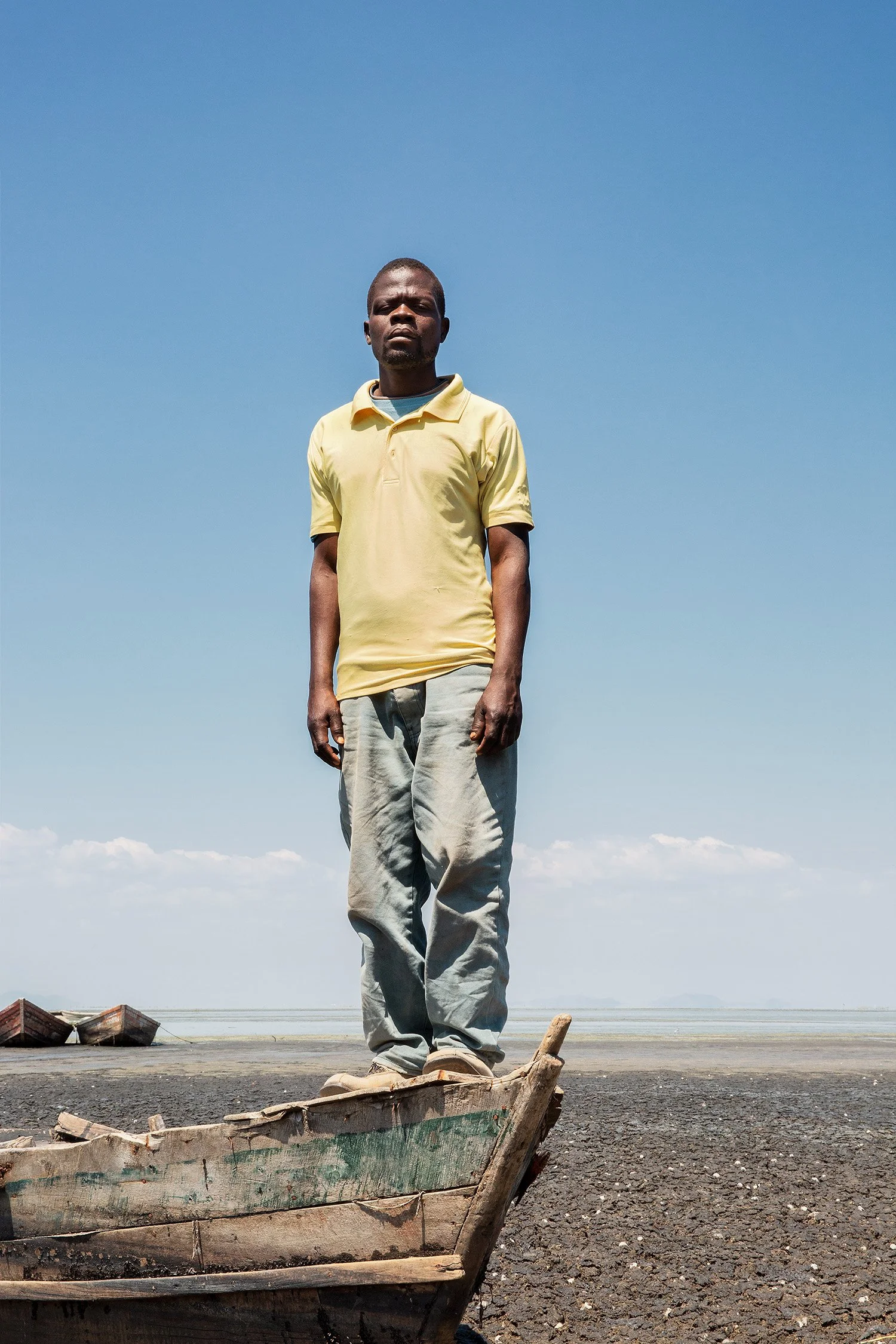 A fisherman stands on the front end of an abandoned fishing boat, Chisi Island, Lake Chilwa.