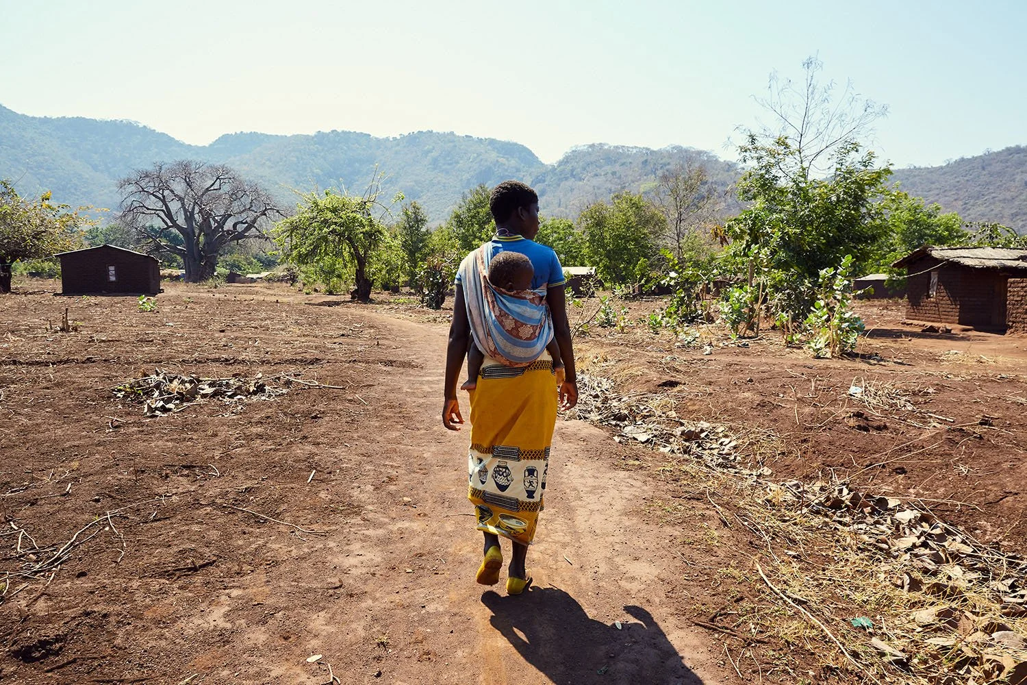 Female Fishtrader walks home with her one-year-old son, Chisi Island, Lake Chilwa.