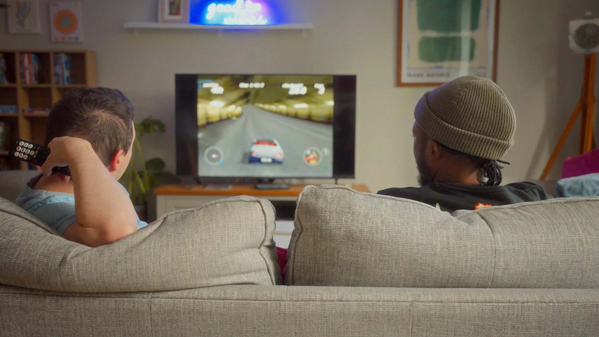 A man watches TV with his Support Worker.