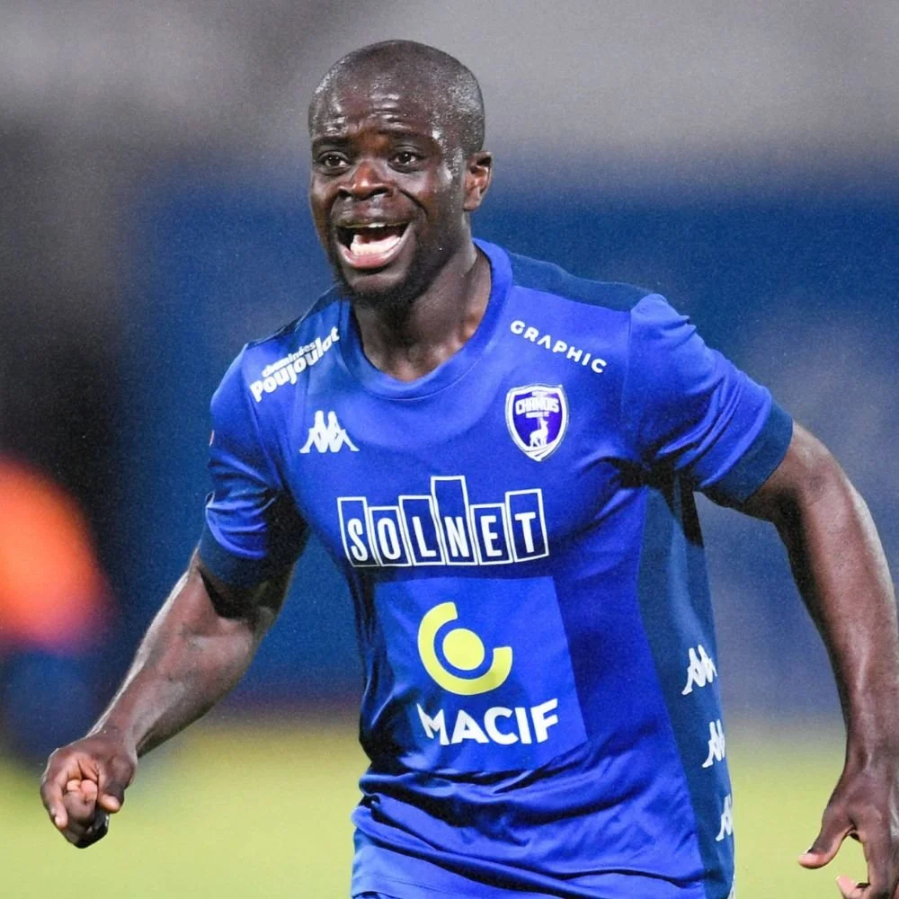 A male soccer player in a blue uniform celebrating on the field.