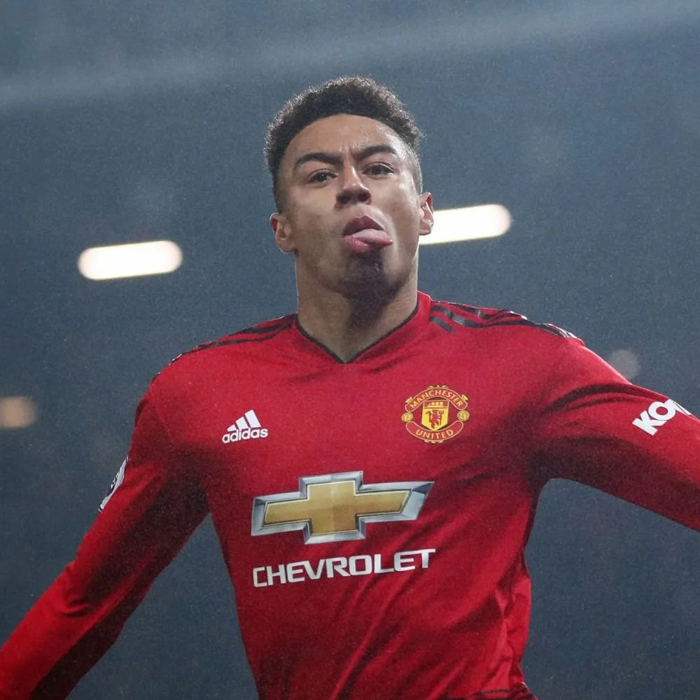 A soccer player in a red Manchester United jersey with a Chevrolet logo, celebrating on the field.