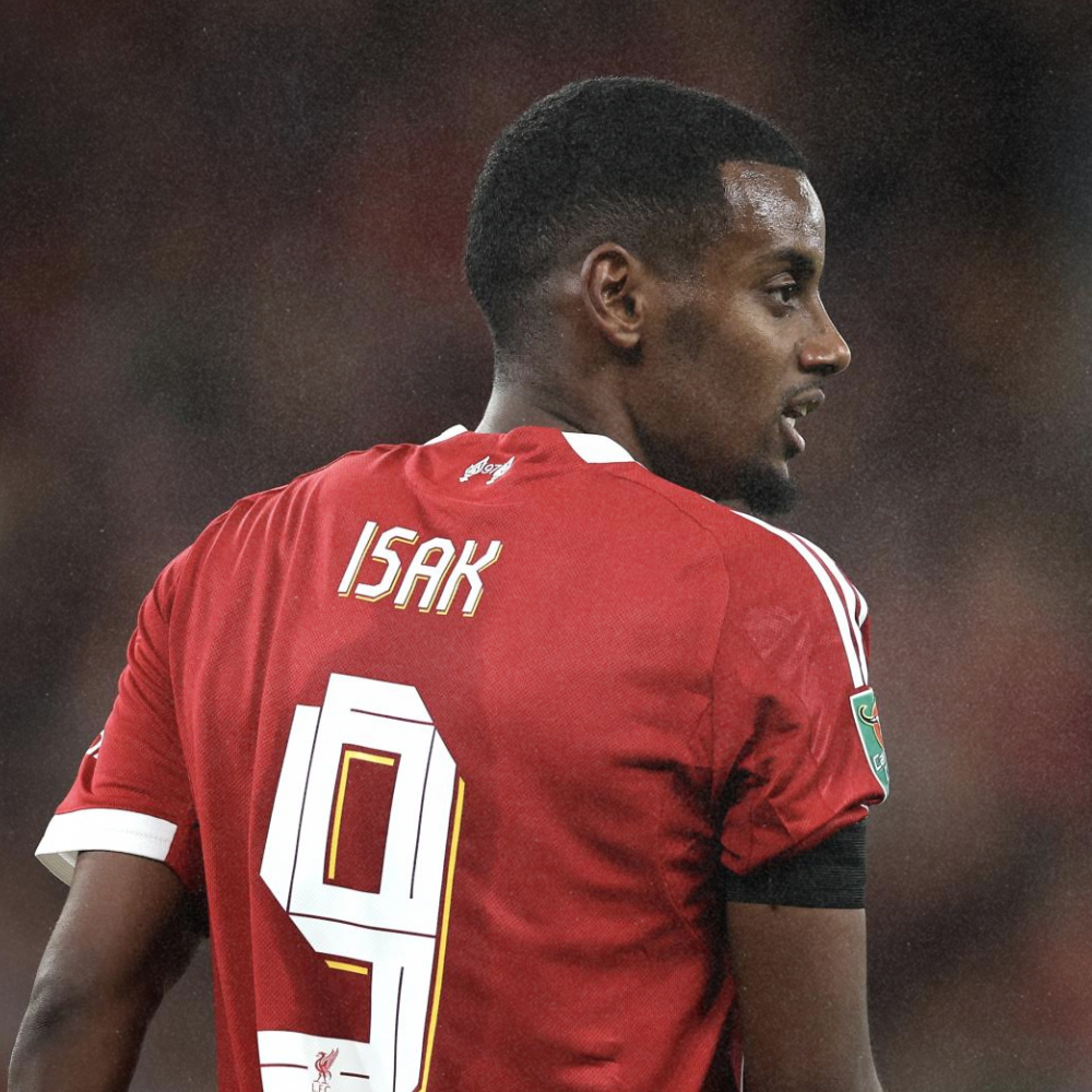 A soccer player wearing a red jersey with the name 'ISAK' and number 9 on the back, standing on the field during a game.