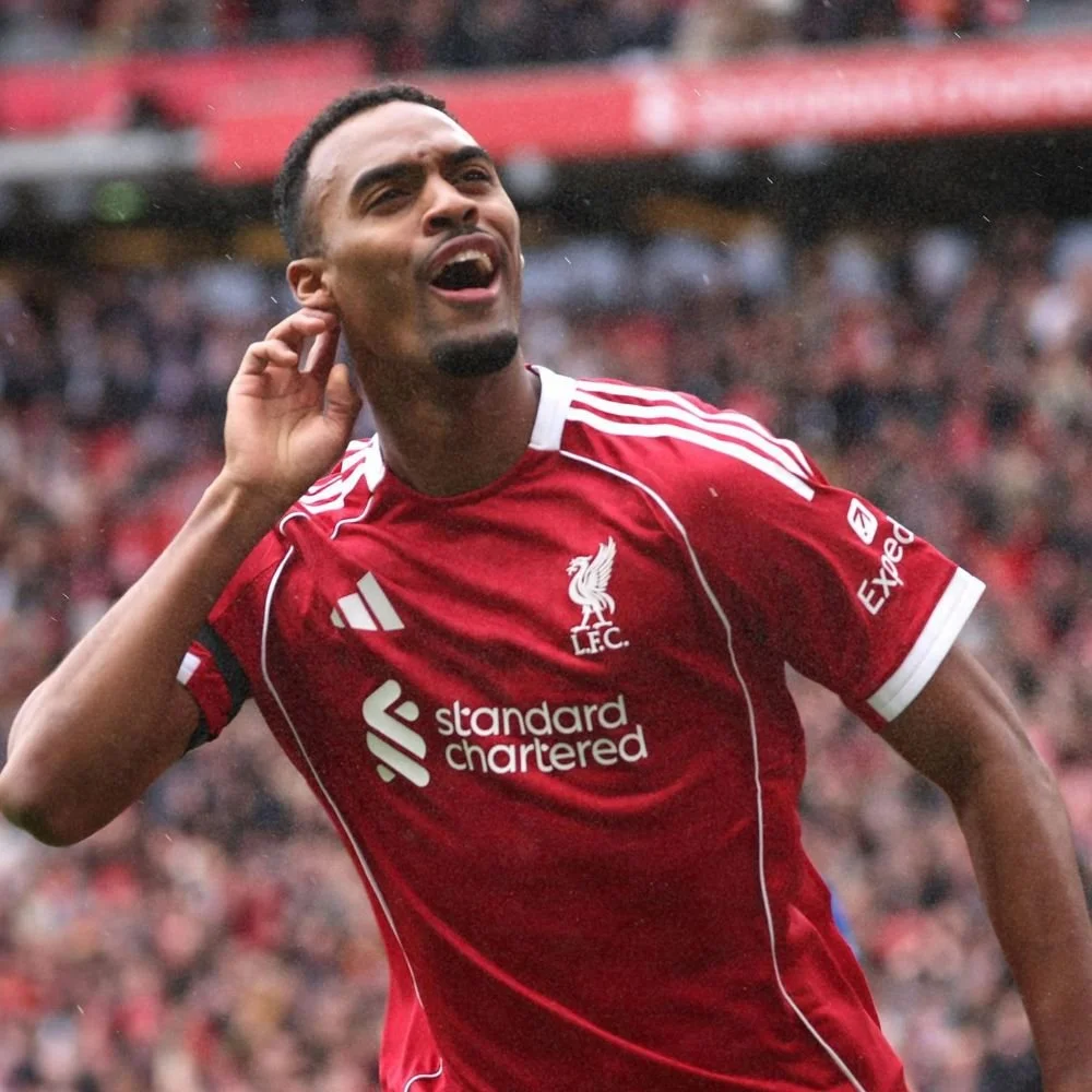 A soccer player in a red Liverpool jersey celebrating on the field.