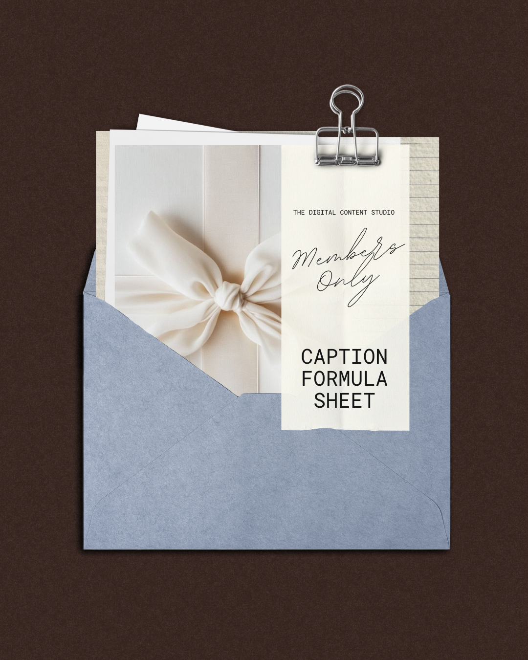 An envelope containing a thank-you card with a white bow, with a paper attached that reads 'Members Only, Caption Formula Sheet, The Digital Content Studio,' clipped with a metal paperclip, on a dark brown background.