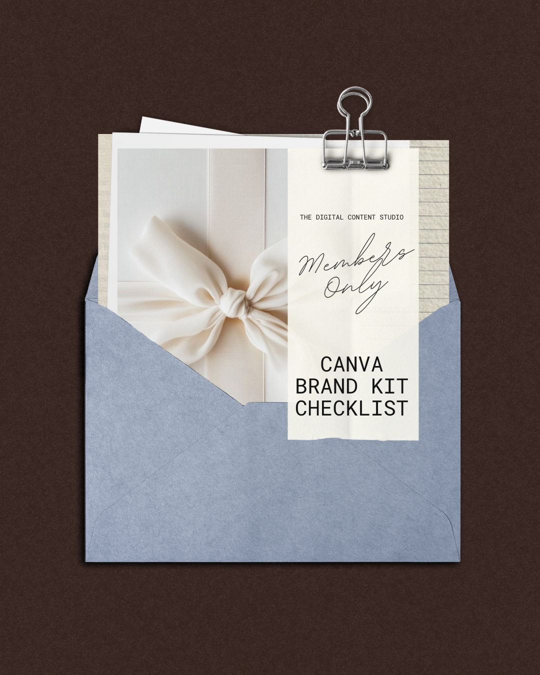 Invitation inside an open blue envelope with a note attached, featuring a photo of a white gift box with a bow, and text that reads 'THE DIGITAL CONTENT STUDIO Members Only CANVA BRAND KIT CHECKLIST' on a paper clip.