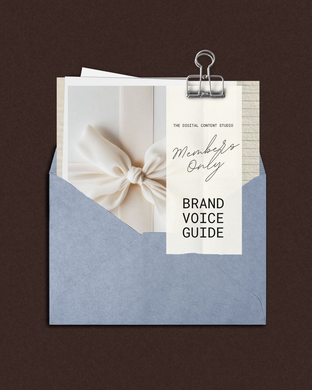 An envelope containing a card with the words 'Members Only Brand Voice Guide' and a photo of a white ribbon tied in a bow, attached with a binder clip on a dark brown background.