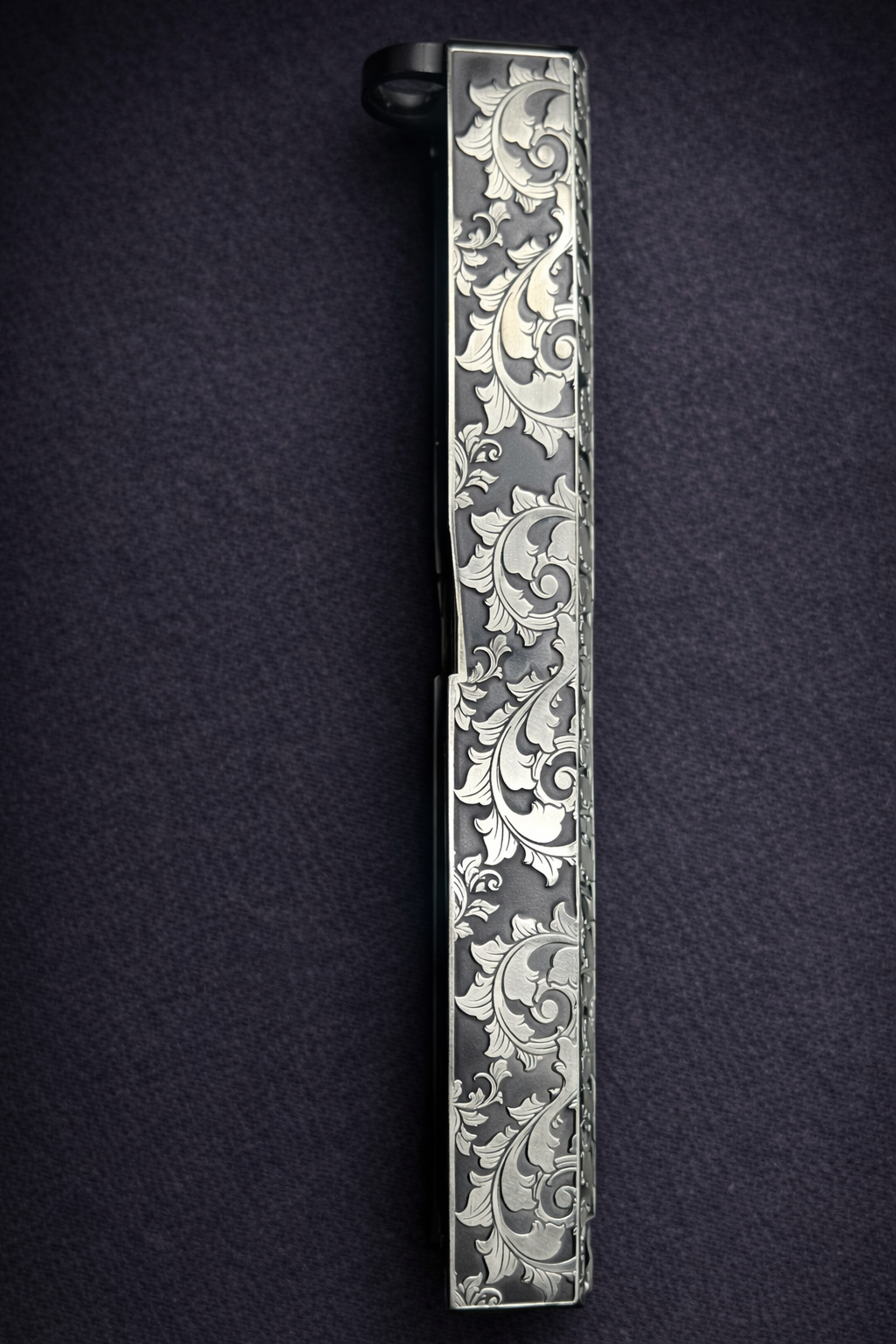 Custom Glock® 17 Gen 5 slide featuring deep engraved, ornate scroll engraving and dark Cerakote backfill finish.