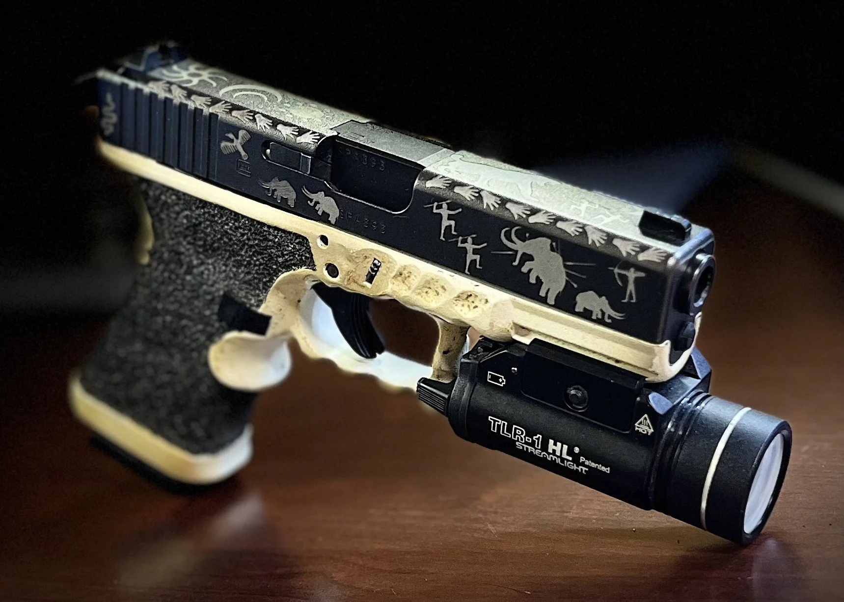 Custom Glock® 19 featuring decorative slide engraving, a two-tone Cerakoted frame, and hand-stippled grip, showcasing detailed craftsmanship and personalized design work.