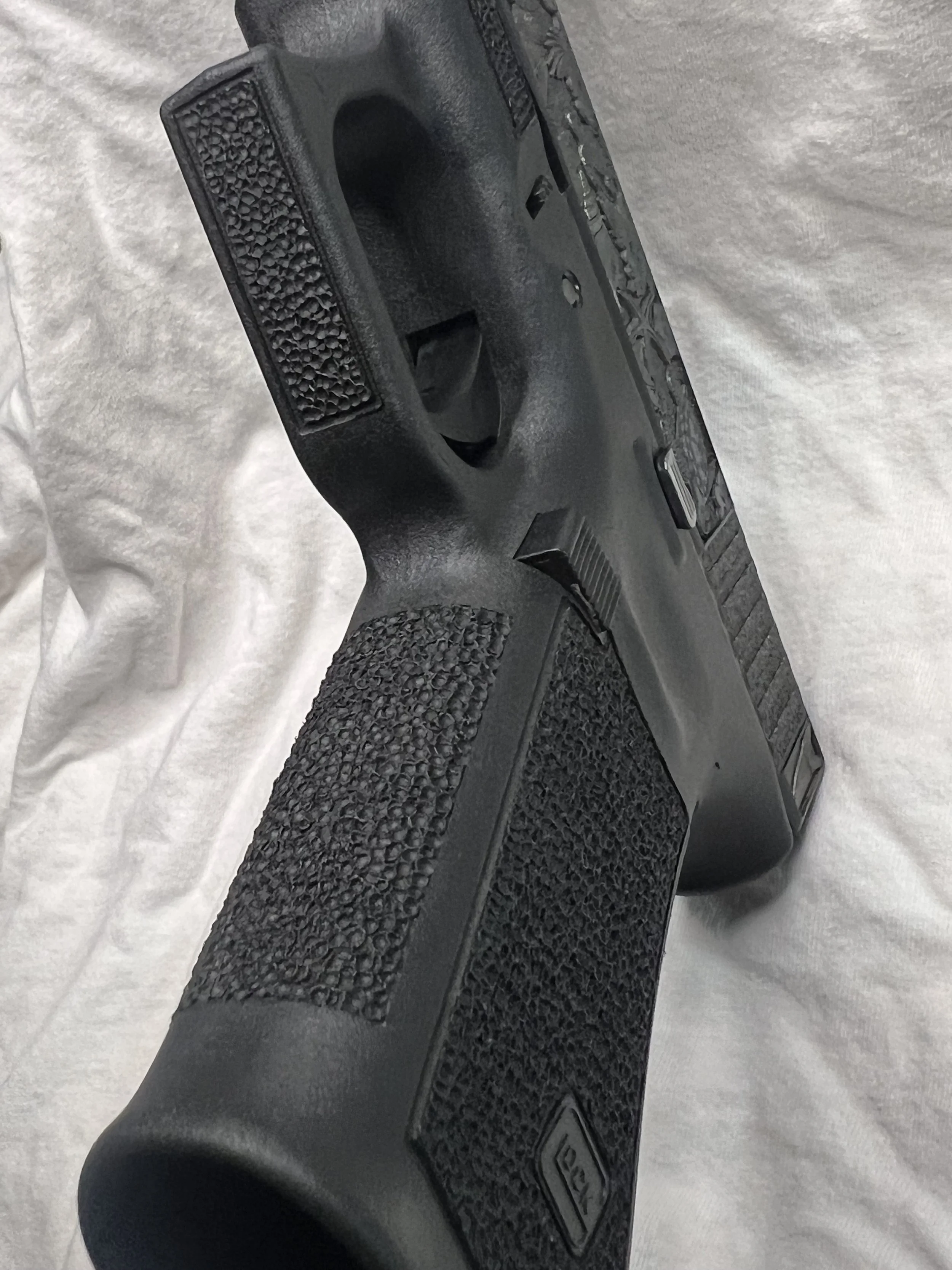 Custom Glock® 40 featuring decorative ocean scene slide engraving with colorful etched artwork and a black hand-stippled frame, showcasing detailed craftsmanship and personalized design work.
