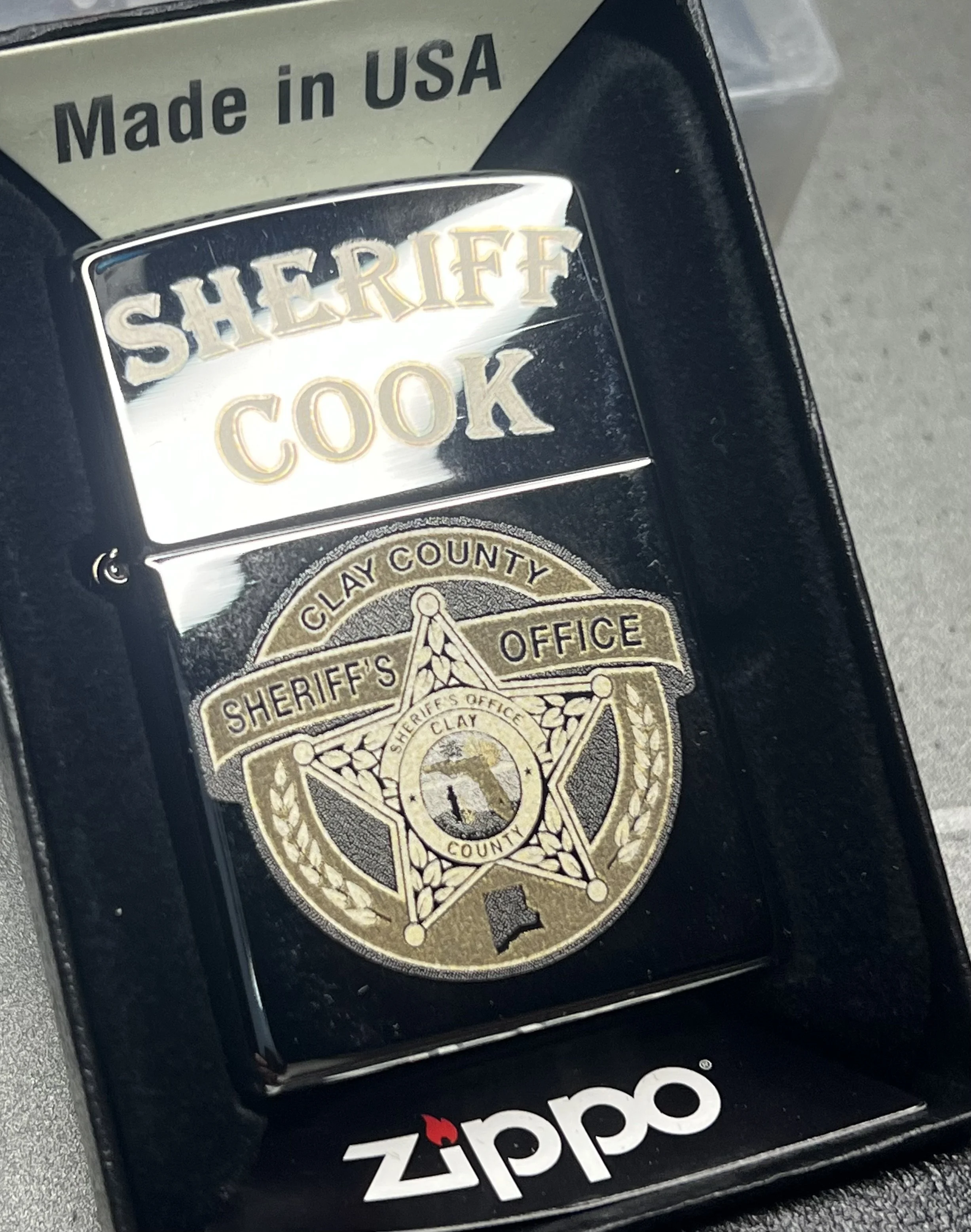 Custom Zippo® lighter engraved with a sheriff’s department badge and personalized text, created as a commemorative piece for a local law enforcement client and displayed in a branded presentation box.