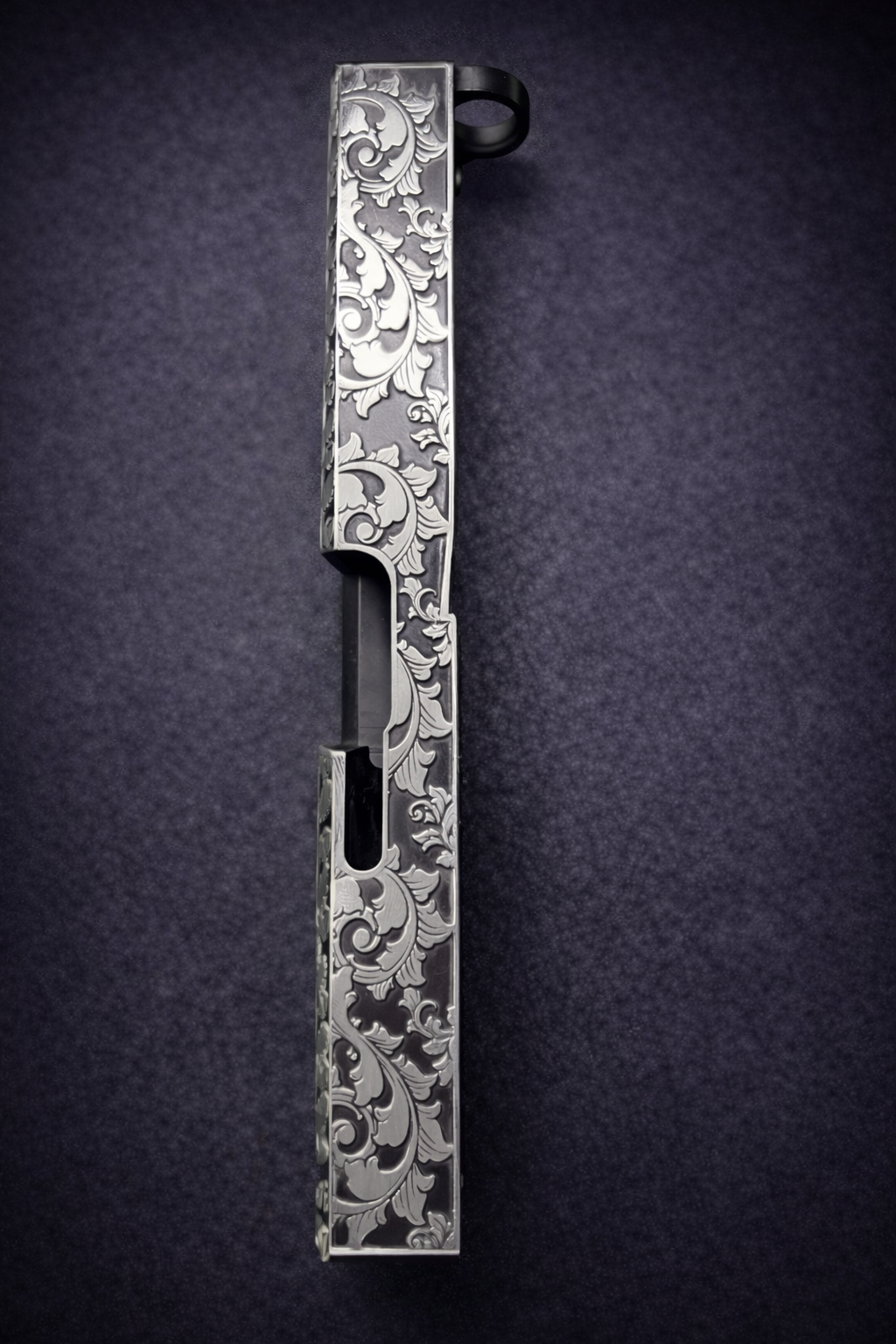 Custom Glock® 17 Gen 5 slide featuring deep engraved, ornate scroll engraving and dark Cerakote backfill finish.