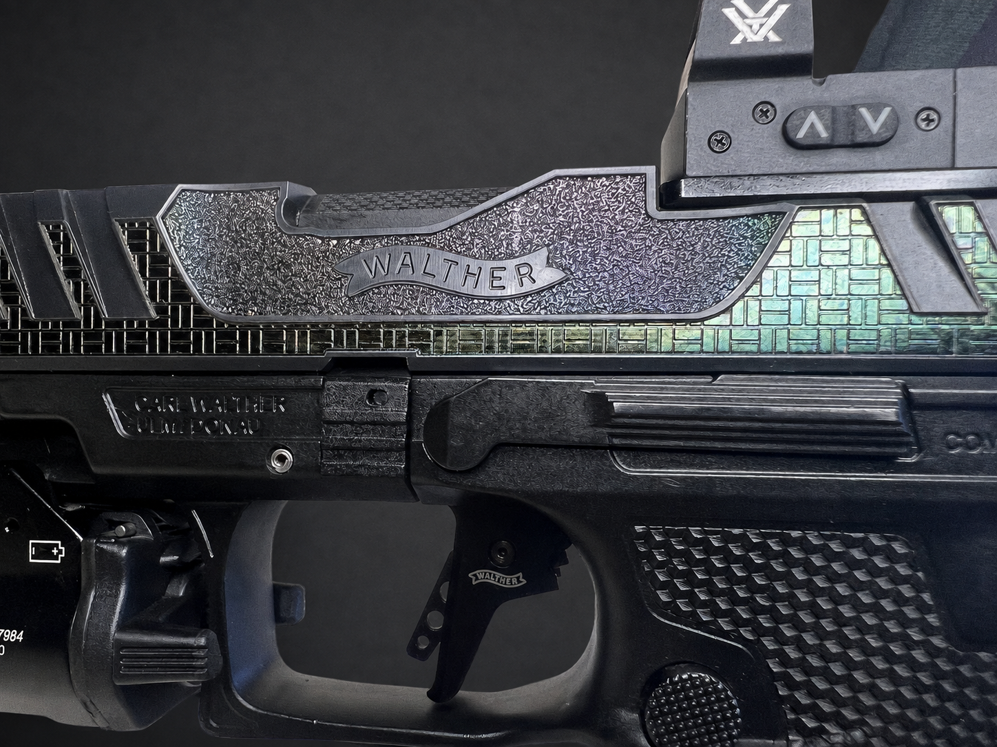 Close-up of custom Walther PDP Pro laser-polished geometric slide artwork and textured grip in a studio product photo