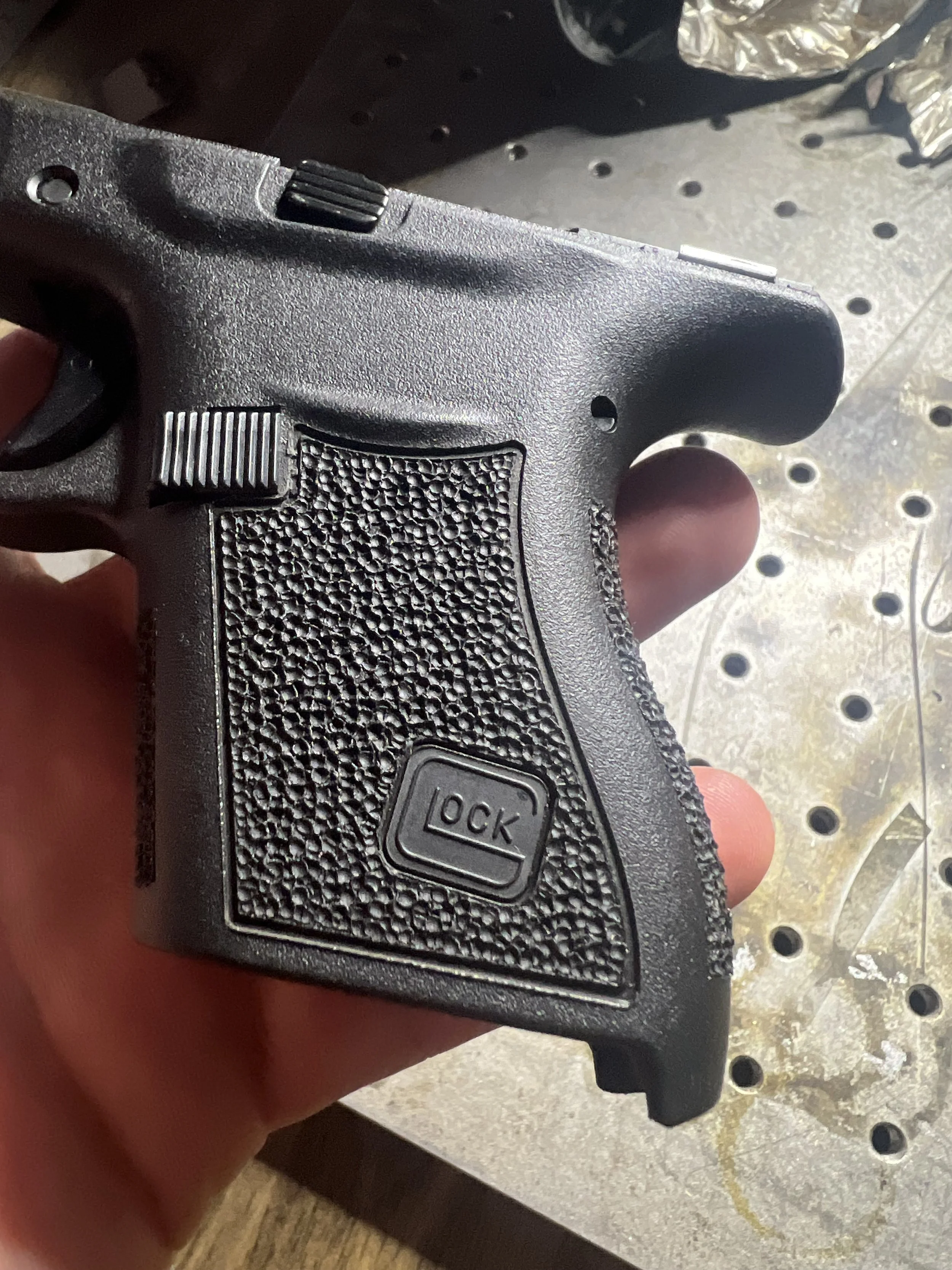 Close-up of a Glock® 43 frame featuring custom hand stippling with a uniform textured pattern, showcasing detailed craftsmanship and personalized grip work.