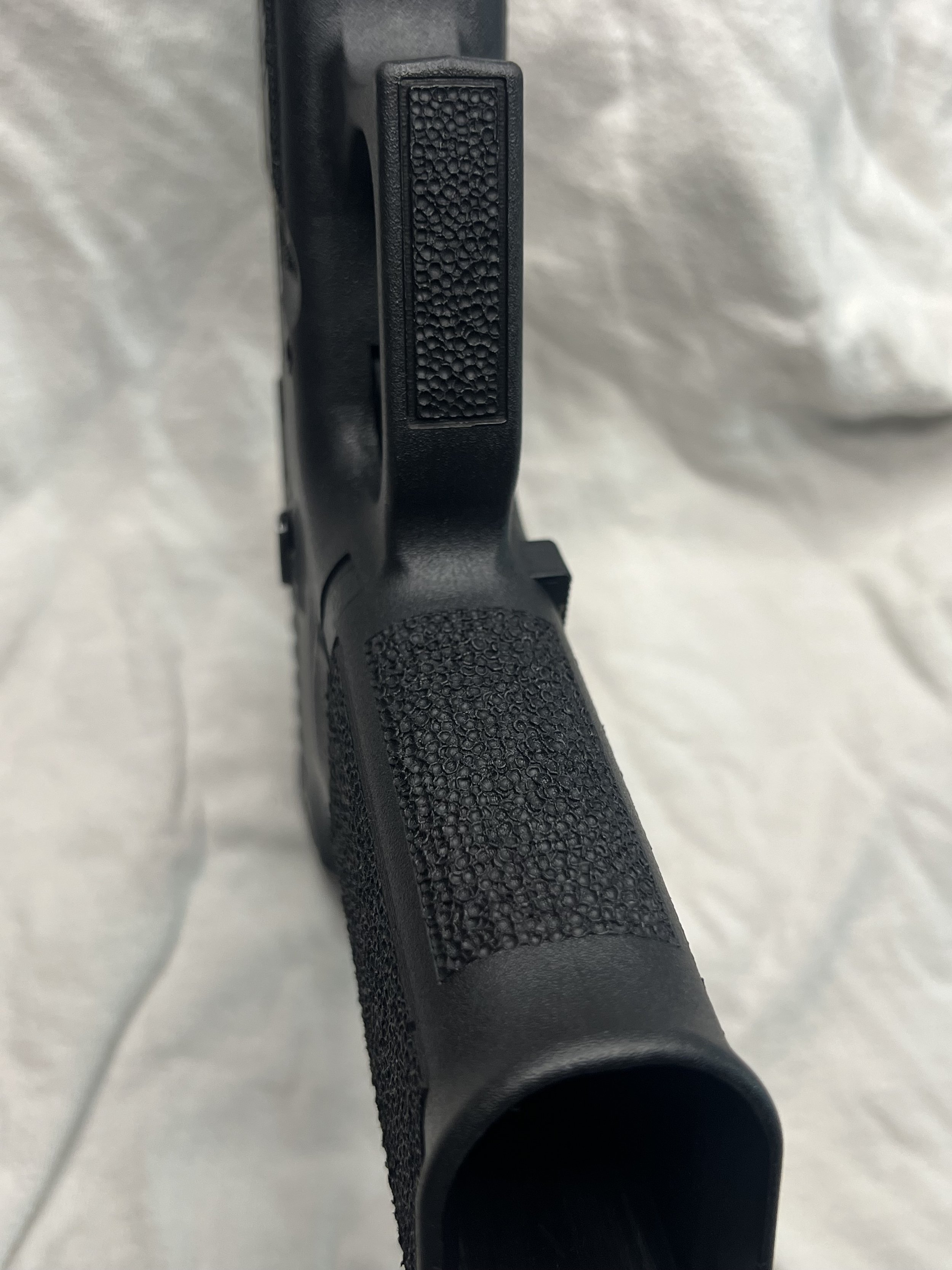 Custom Glock® 40 featuring decorative ocean scene slide engraving with colorful etched artwork and a black hand-stippled frame, showcasing detailed craftsmanship and personalized design work.
