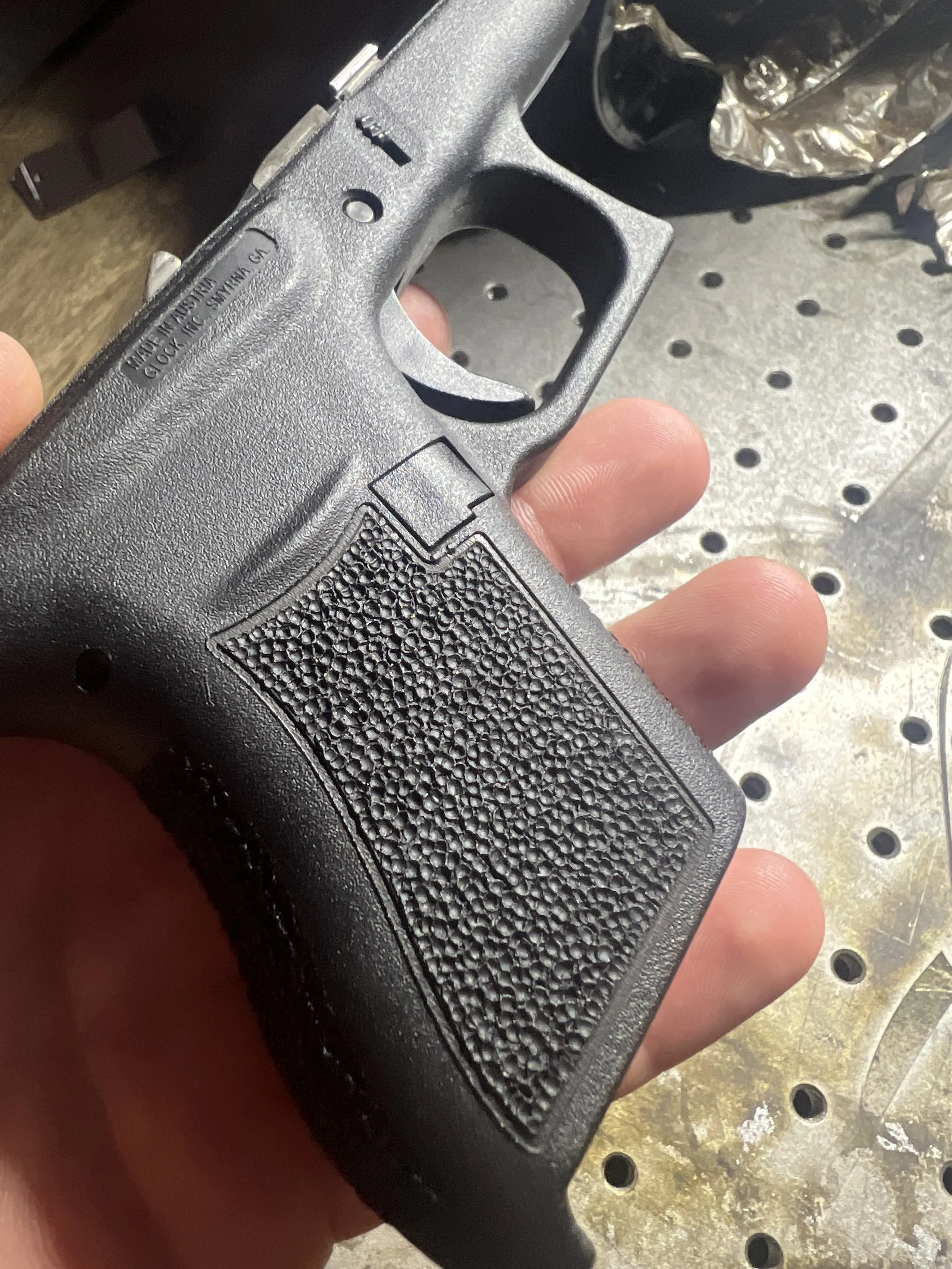 Close-up of a Glock® 43 frame featuring custom hand stippling with a uniform textured pattern, showcasing detailed craftsmanship and personalized grip work.