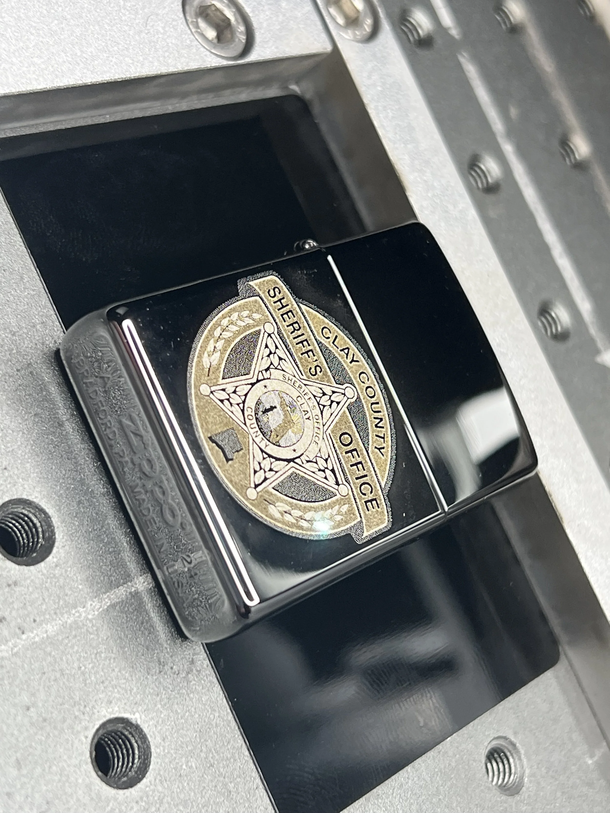 Custom Zippo® lighter engraved with a sheriff’s department badge and personalized text, created as a commemorative piece for a local law enforcement client and displayed in a branded presentation box.