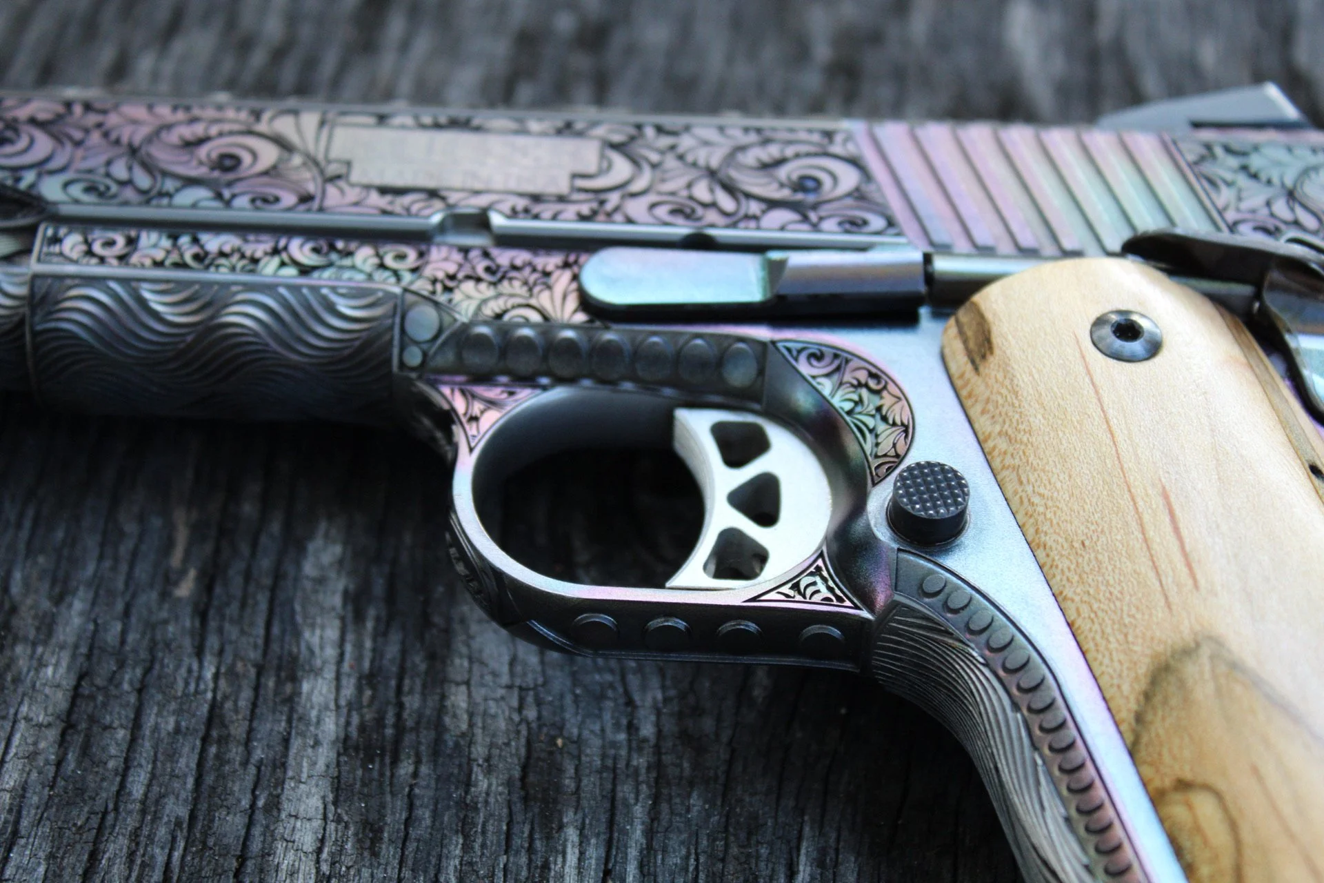 One-of-a-kind Ruger® 1911 featuring intricate scroll engraving, iridescent metal finish, and wood grip panels, custom designed and engraved for a client.
