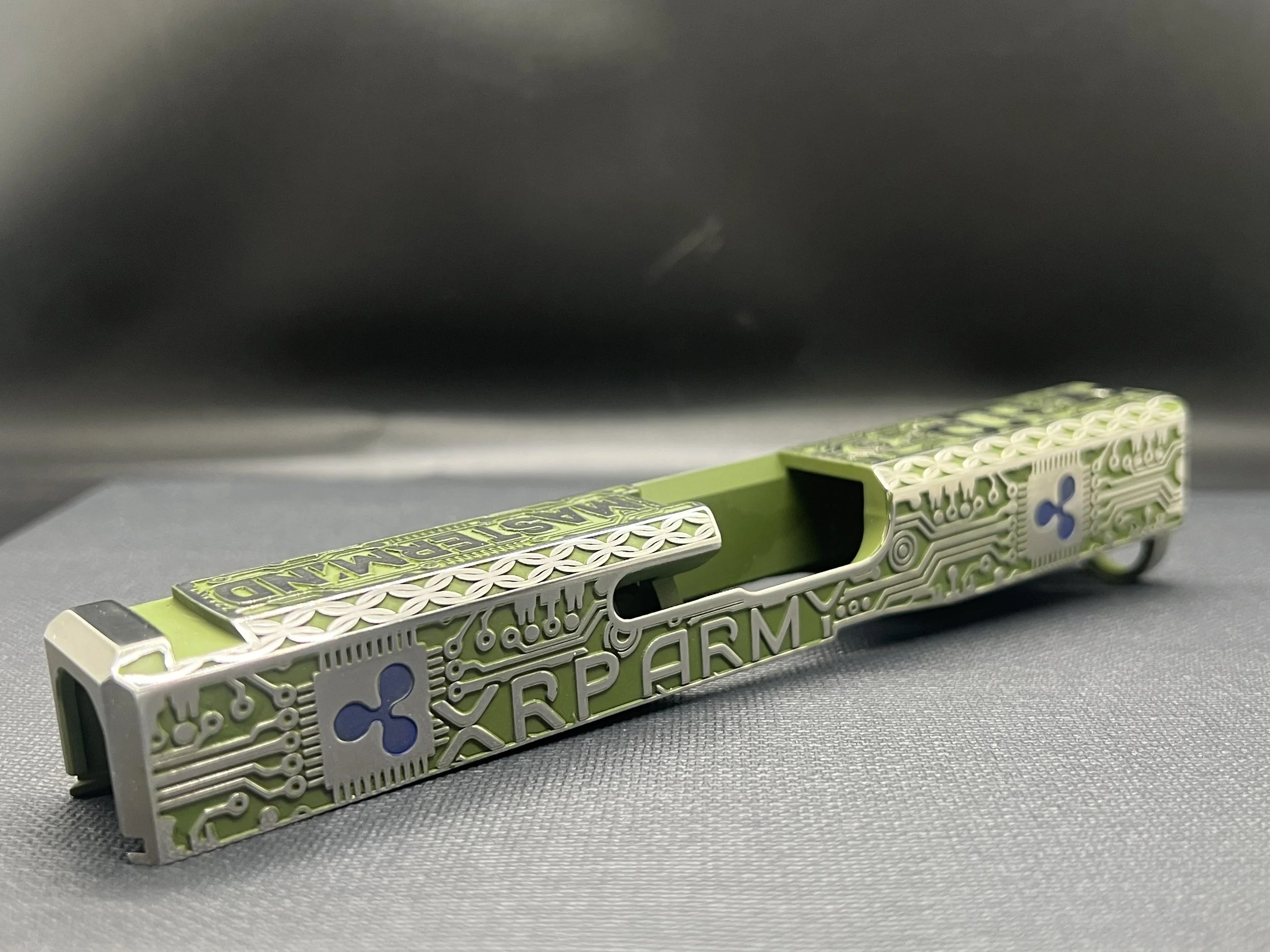 Custom Glock® 17 Gen 5, Ripple XRP themed, slide with circuit-style engraving and green Cerakote finish, designed, laser engraved, and custom finished for a client project.
