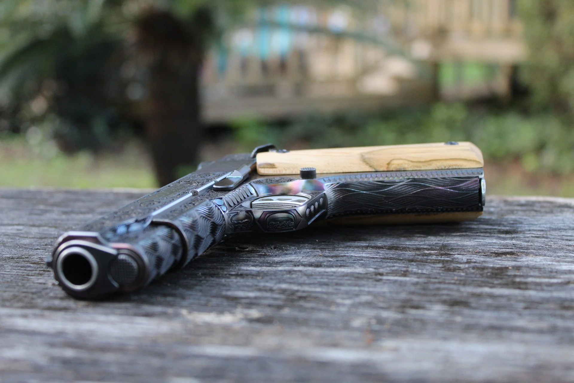 One-of-a-kind Ruger® 1911 featuring intricate scroll engraving, iridescent metal finish, and wood grip panels, custom designed and engraved for a client.
