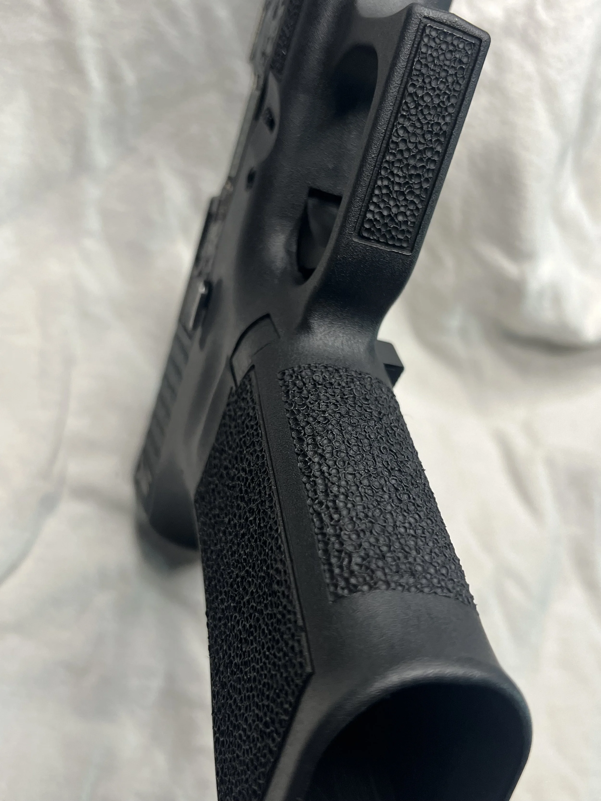 Custom Glock® 40 featuring decorative ocean scene slide engraving with colorful etched artwork and a black hand-stippled frame, showcasing detailed craftsmanship and personalized design work.