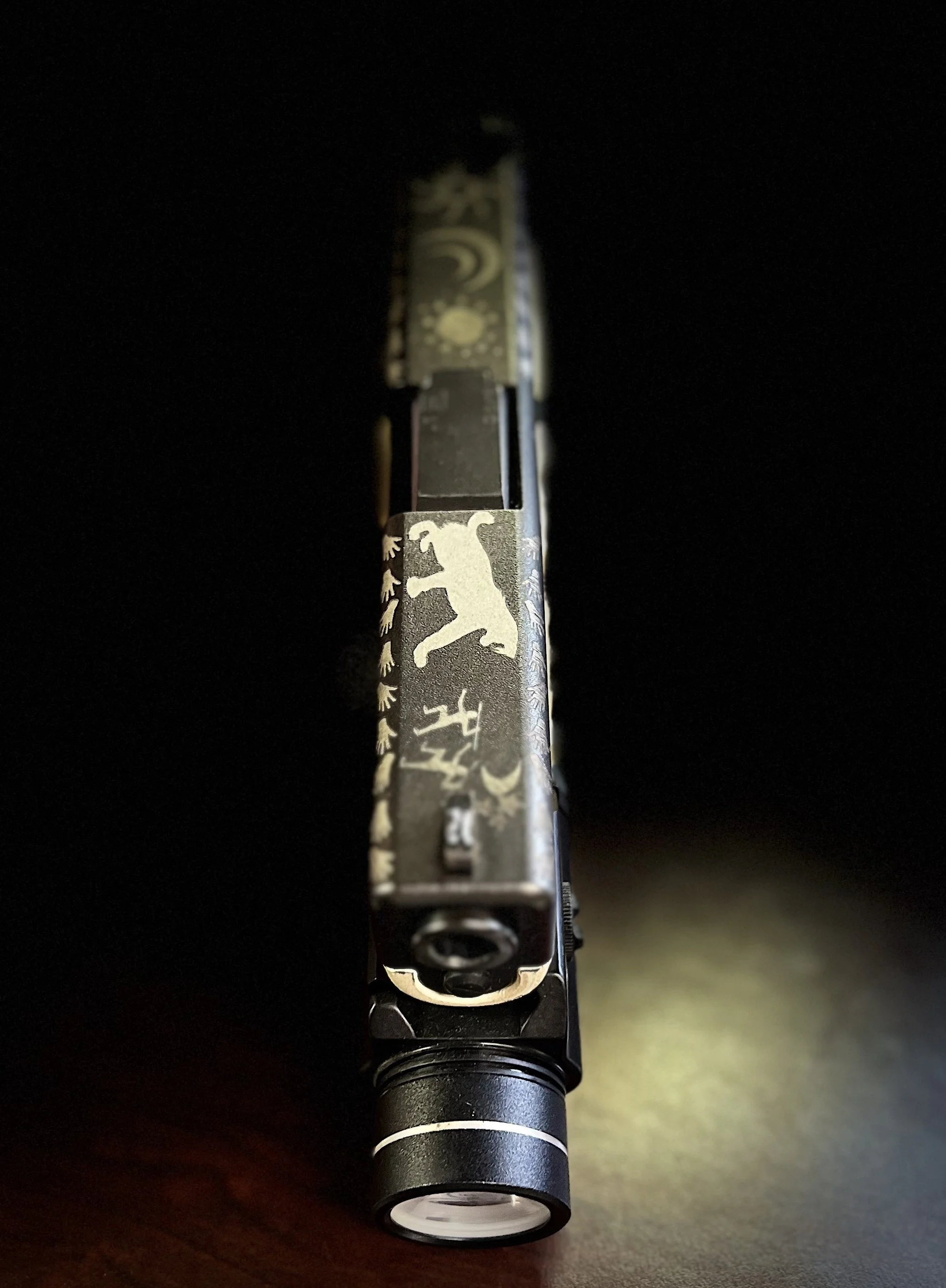 Custom Glock® 19 featuring decorative slide engraving, a two-tone Cerakoted frame, and hand-stippled grip, showcasing detailed craftsmanship and personalized design work.
