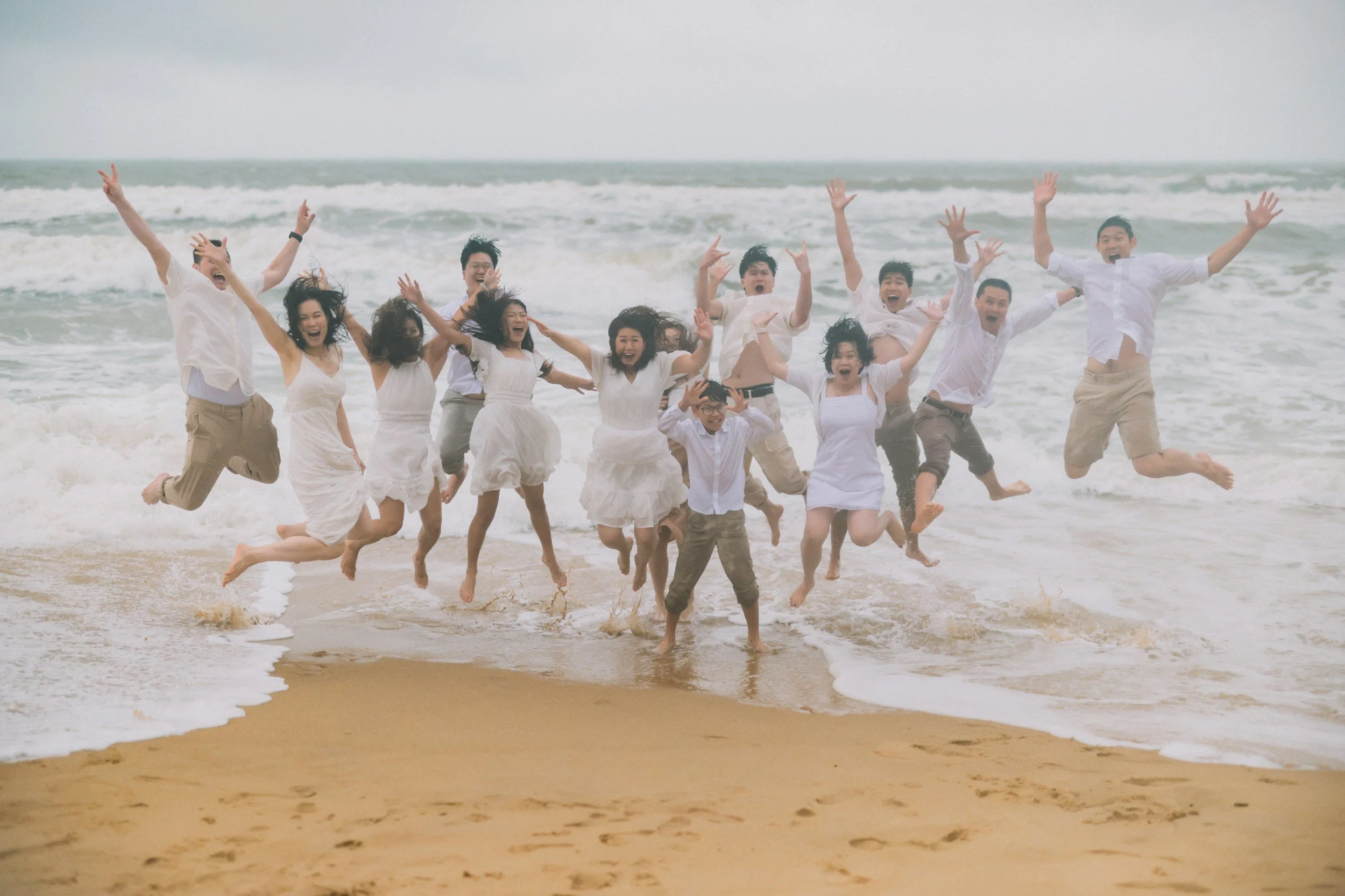 Group of travelers celebrating on the beach, reflecting a shared group travel experience