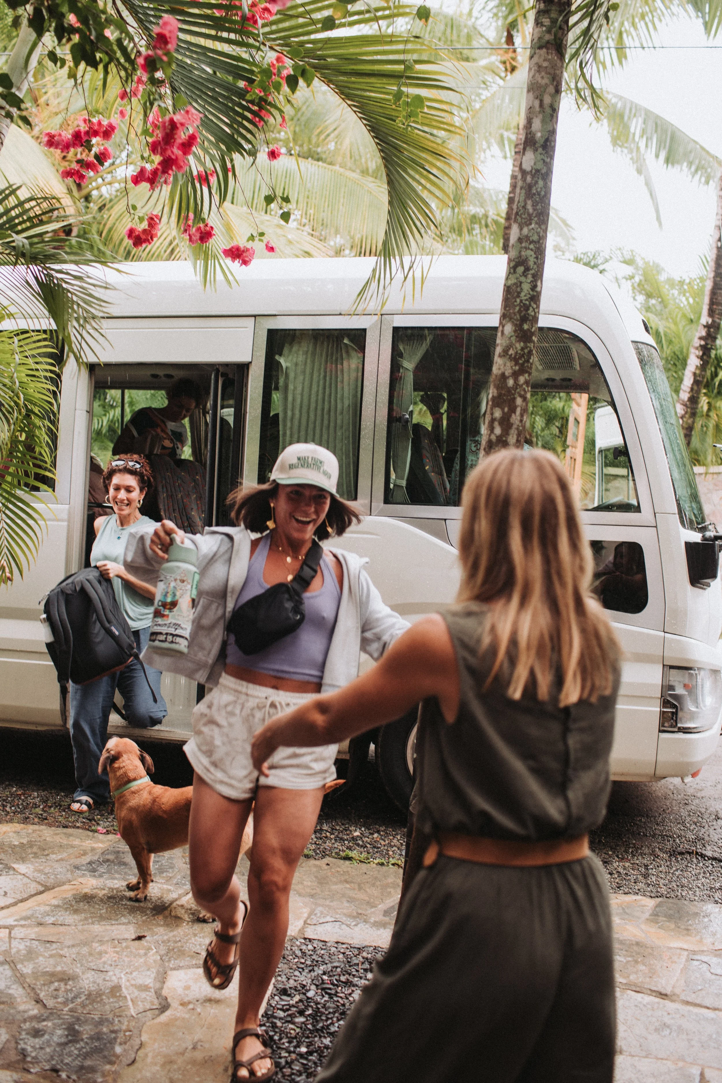 Travelers greeting each other during a group travel experience in a tropical setting