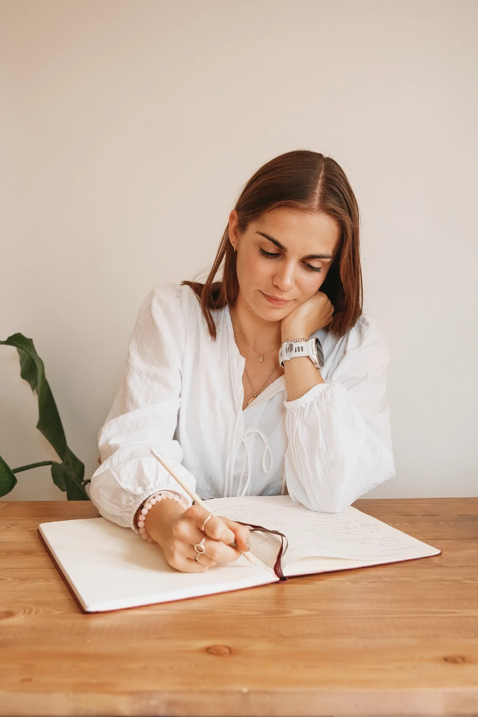 Georgina Howell sitting at desk, writing in notebook