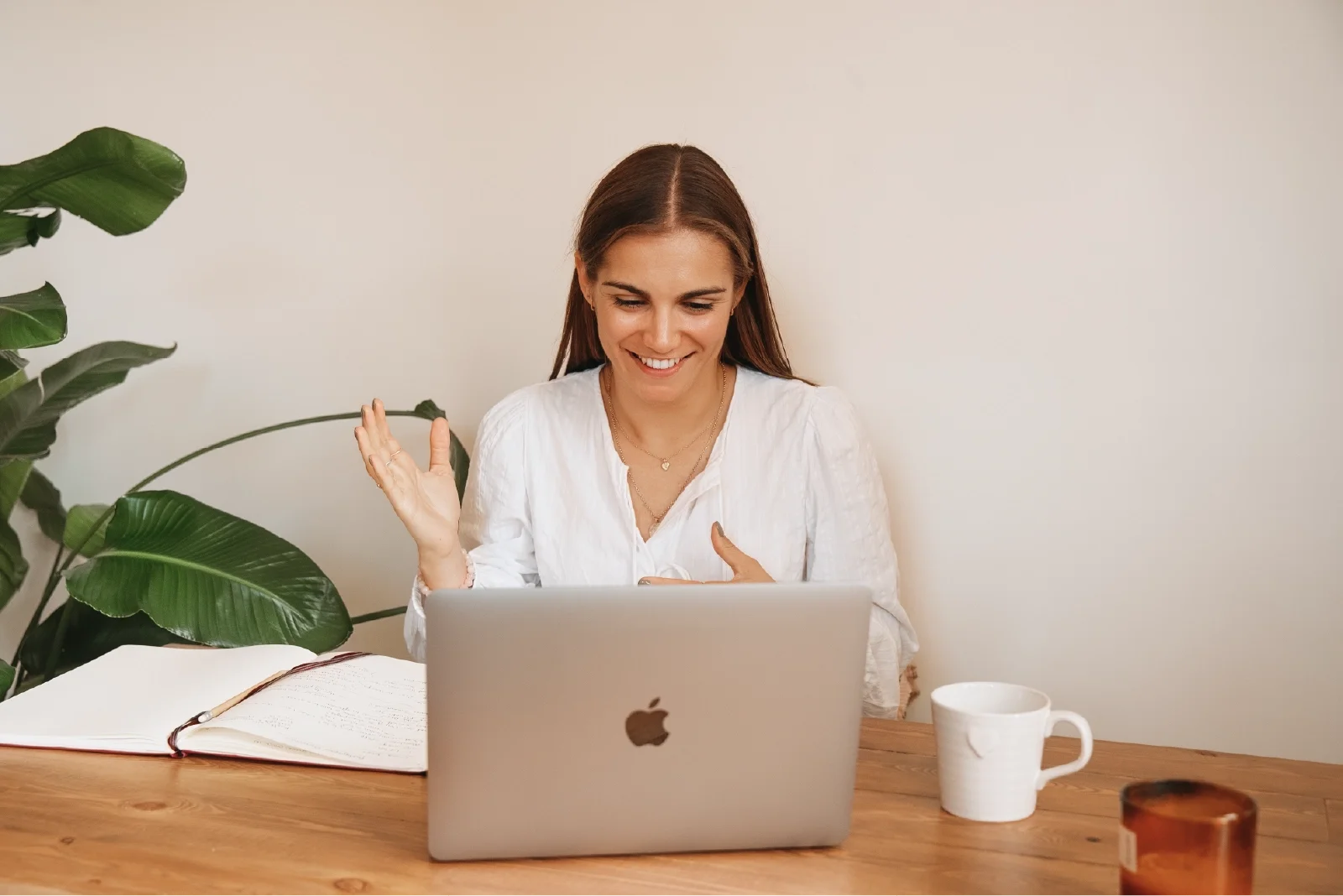 Georgina Howell sitting at desk with laptop in front of her, speaking to a client over zoom.