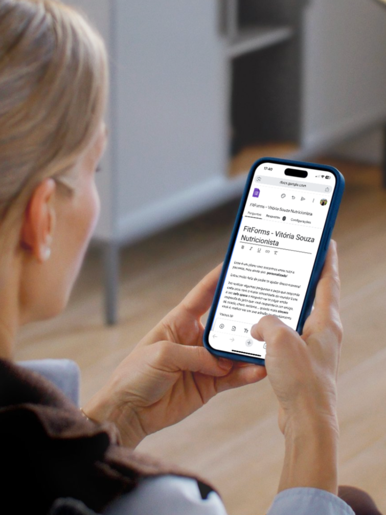 Pessoa assistindo uma página na internet no celular, que exibe um artigo sobre Vitória Souza, nutricionista.
