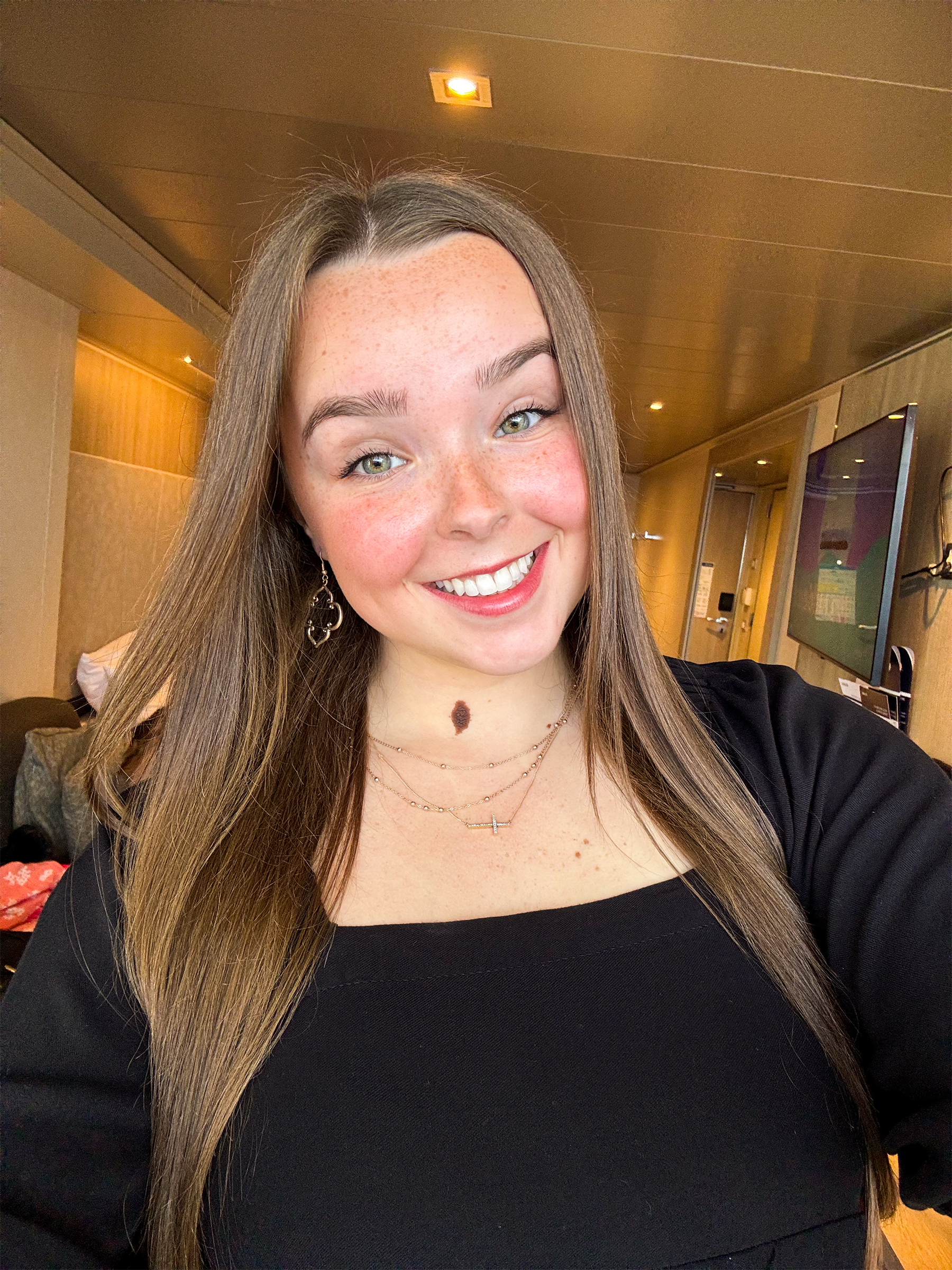 A girl wearing a black dress smiling.