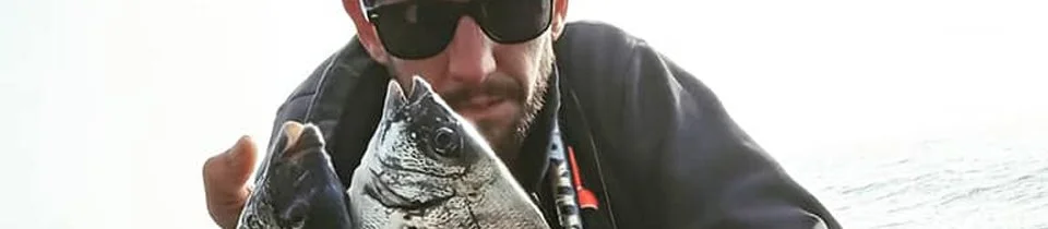 Homem com óculos escuros segurando um peixe