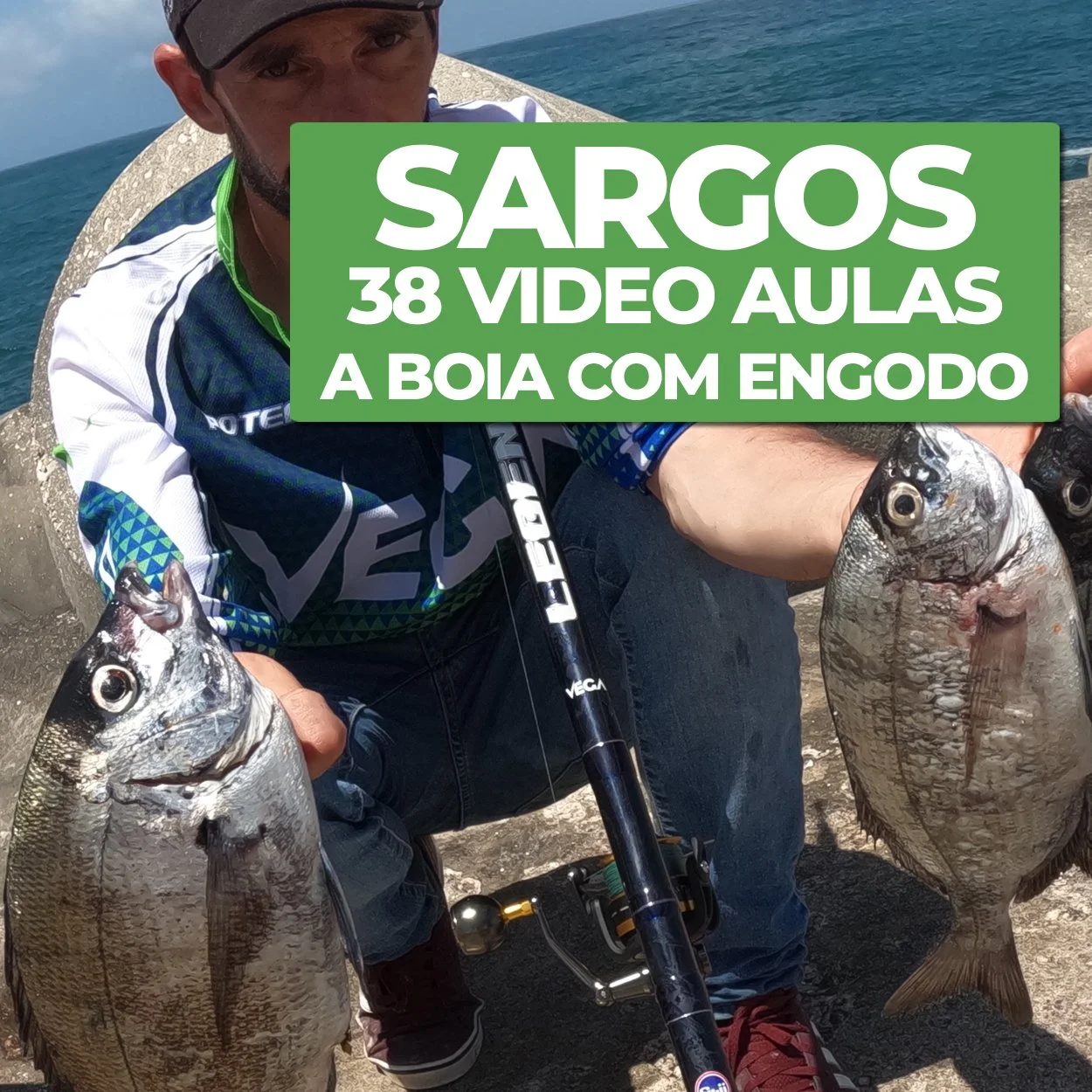 Homem segurando duas peixes de tamanho grande na praia, com o mar ao fundo, e uma placa verde com texto em português.