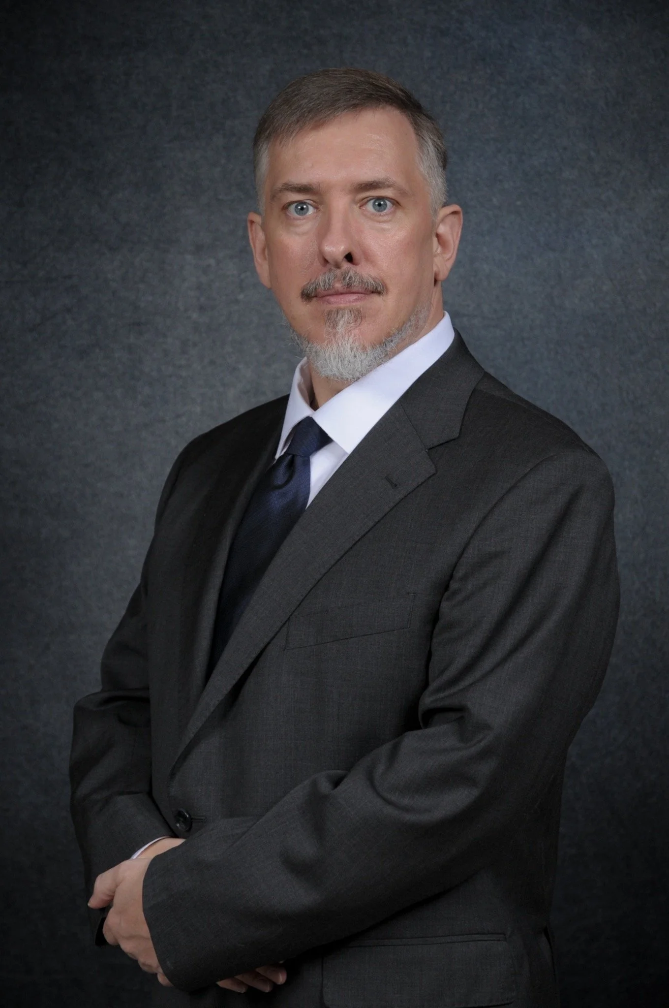 Headshot of Anthony Scharf, founder of E-Sharp Consulting, facing left.