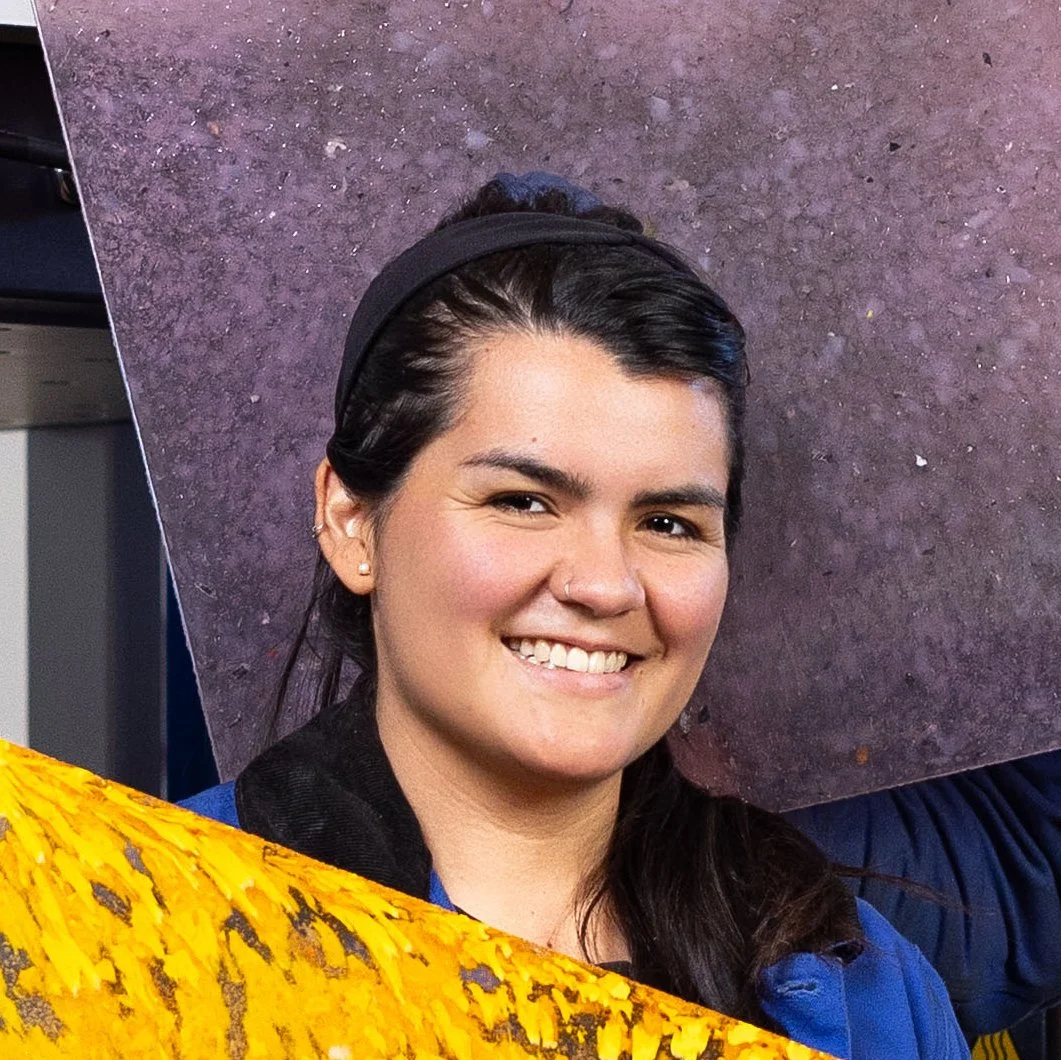 A portrait of Caro, one of the two founders of Mad Plastic, in front of a sheet made from recycled plastic.