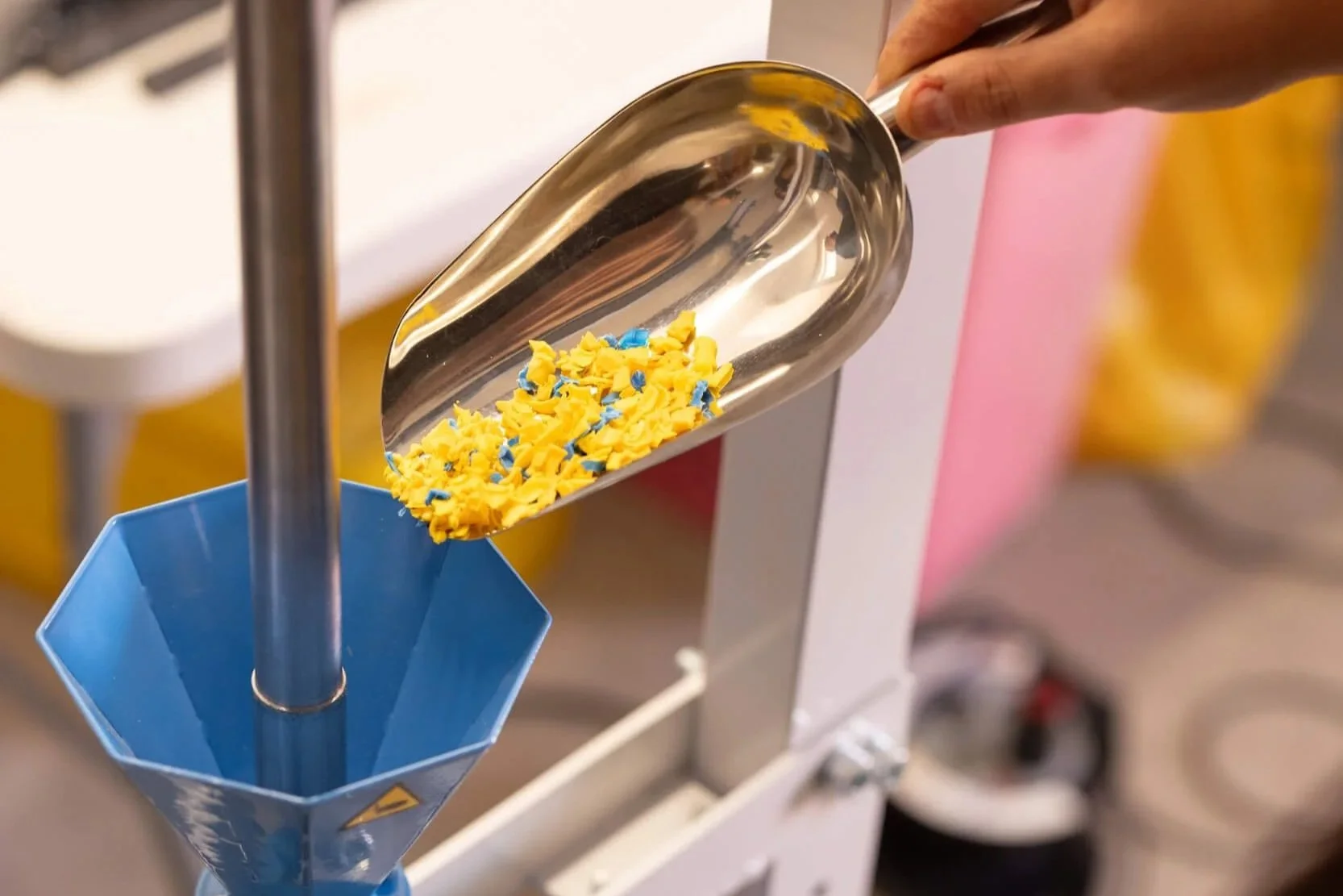 Scooping plastic shreds in the injection machine.