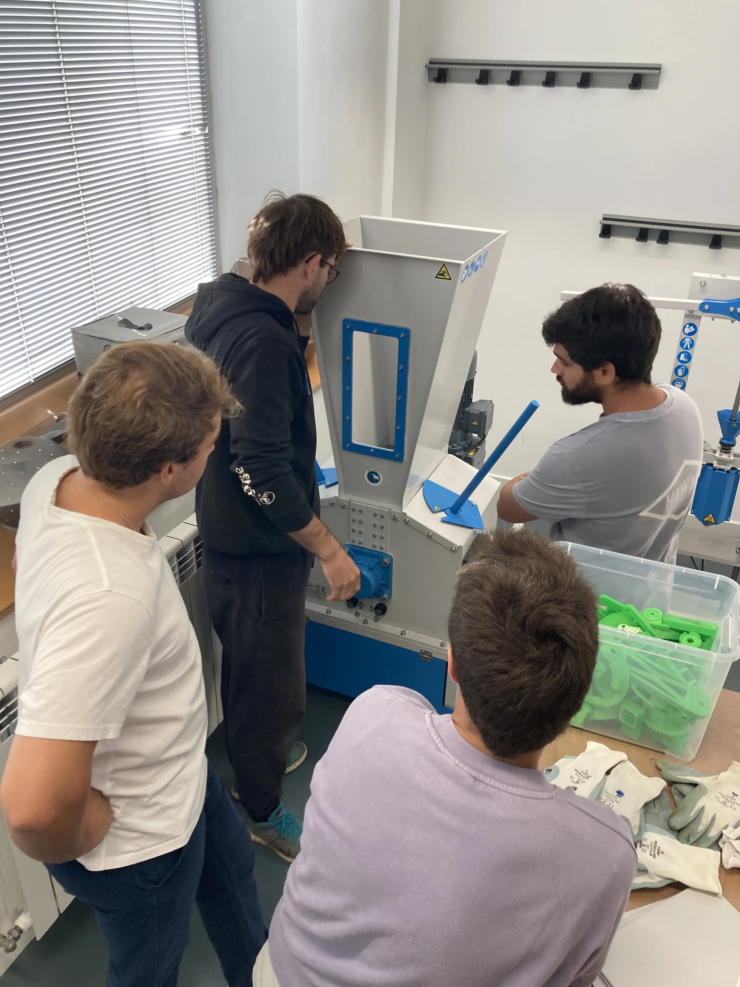 people gathered around the shredder pro during training and explanation on how to use it. 
