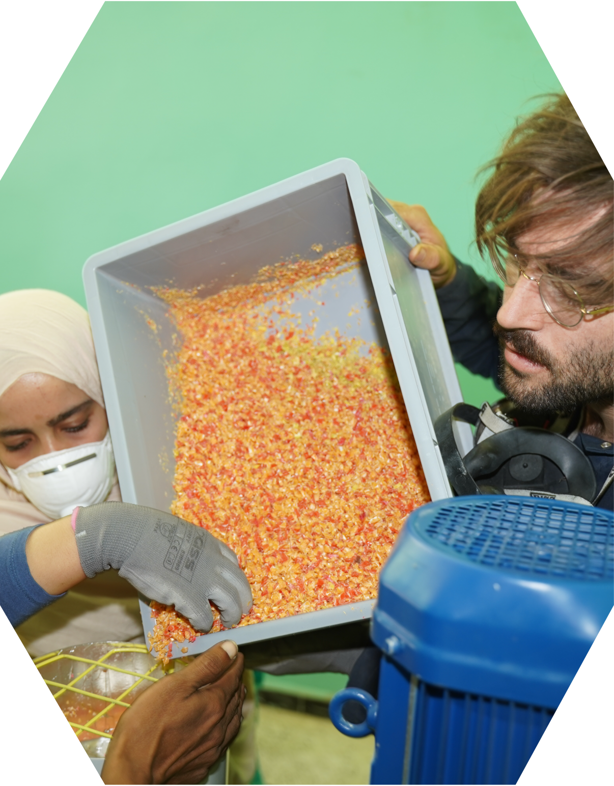 Yann is showing plastic recyclers to-be how to use the Shredder machine.