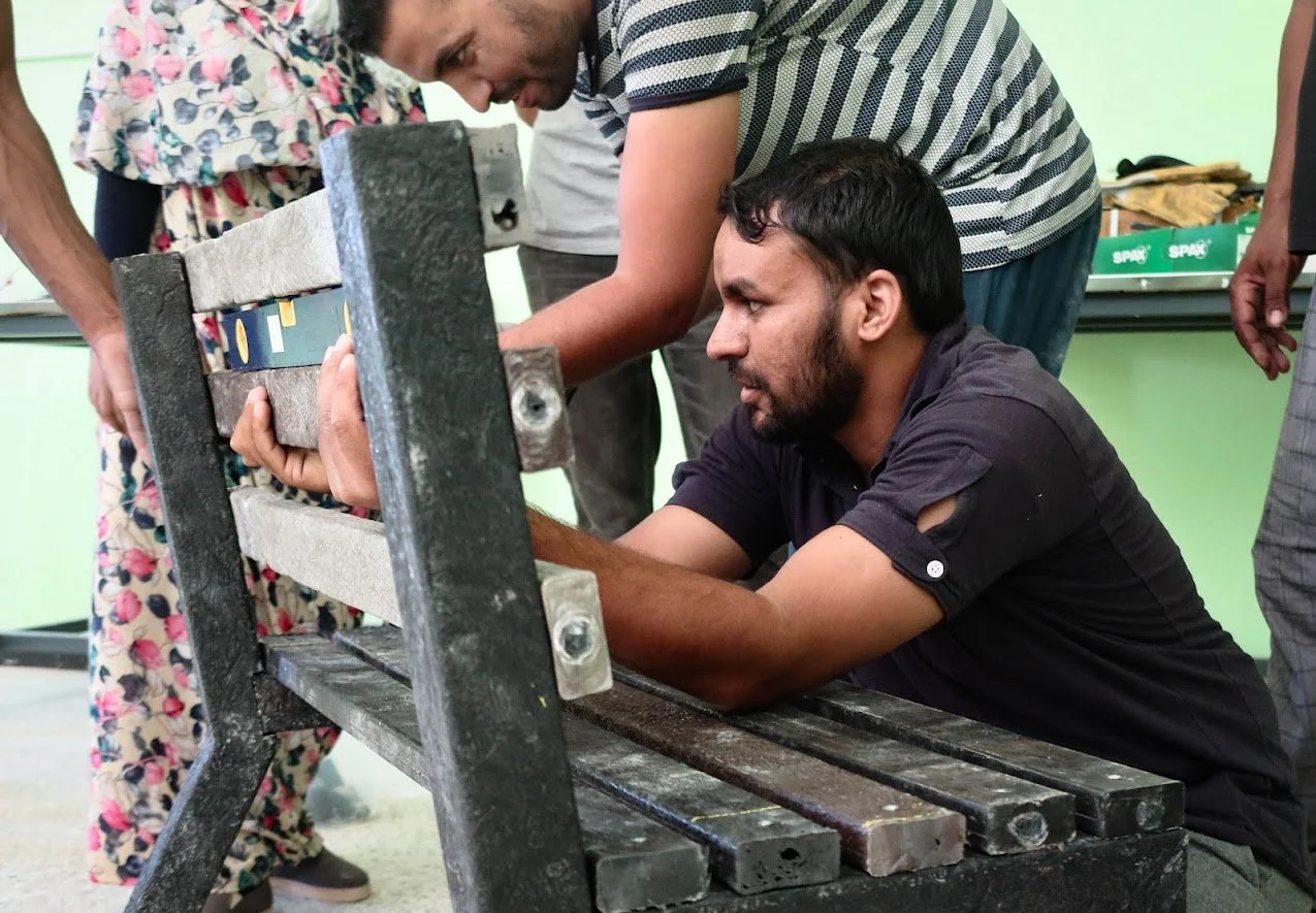 People assembling a recycled plastic bench made with mad plastic machines