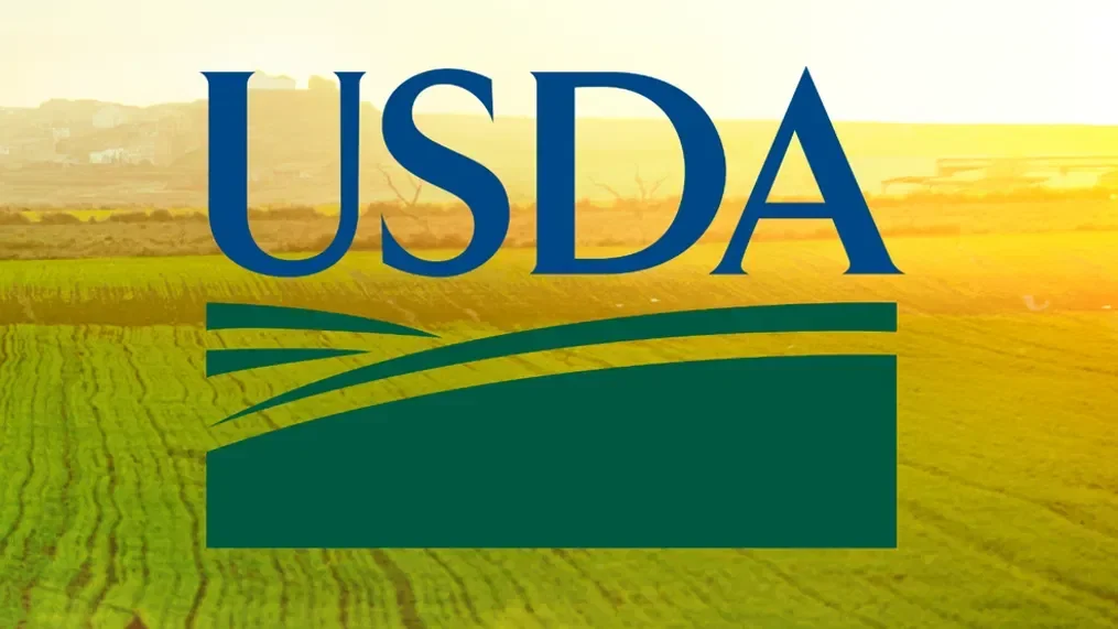USDA logo over a green agricultural field with sunny sky in the background.