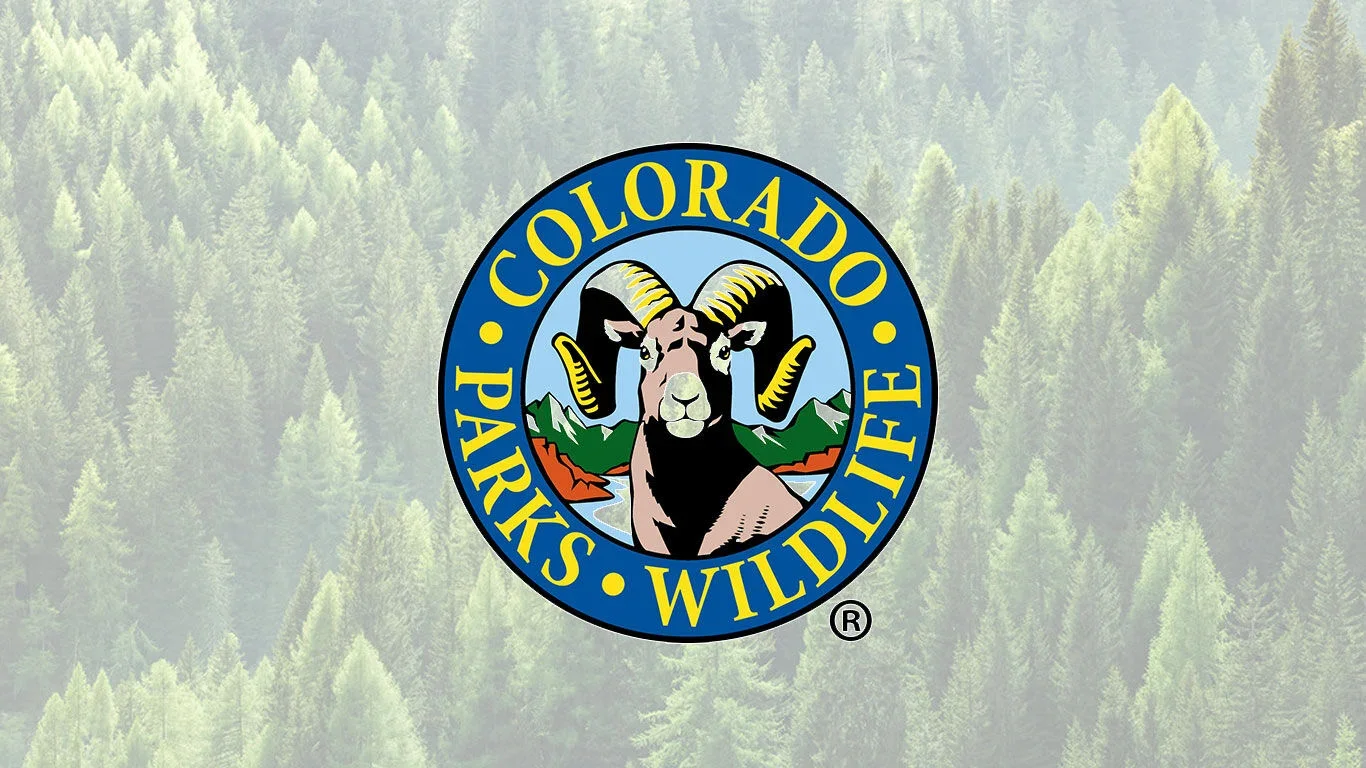 The Colorado Parks and Wildlife logo featuring a mountain goat with black and white horns, set against a backdrop of mountains and a river, with a blue circle border containing yellow text.