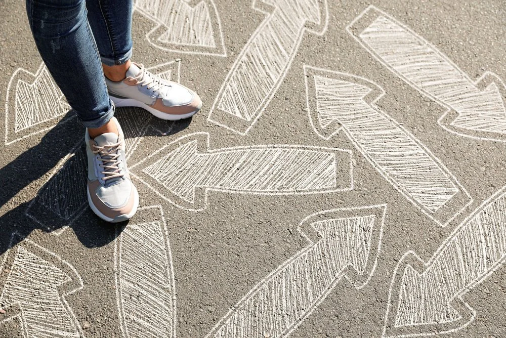 A person's feet and arrows drawn in chalk.