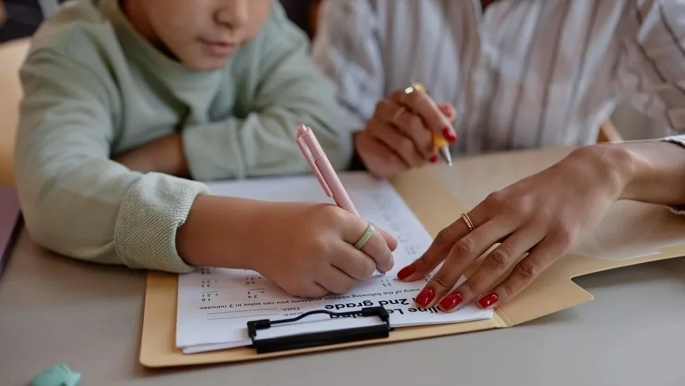 A child and adult working on math homework.