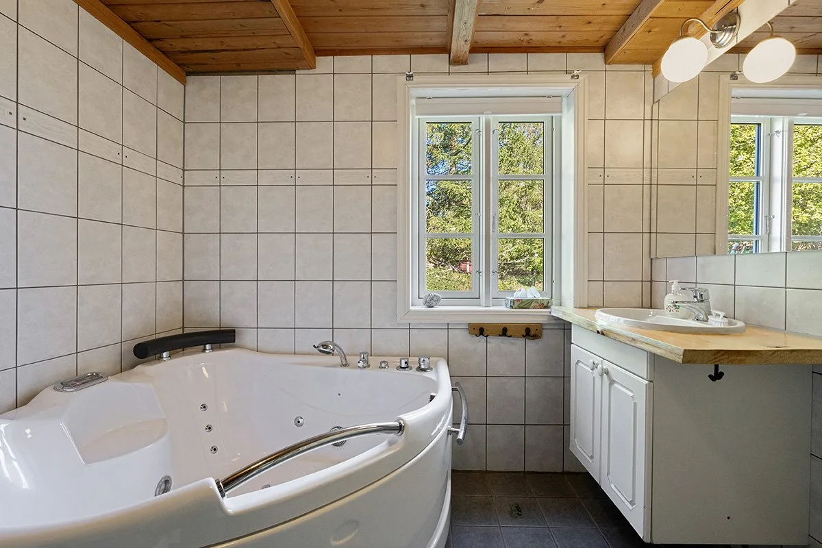 Bathroom, first floor, including a hot tub, a shower, and a washer/dryer