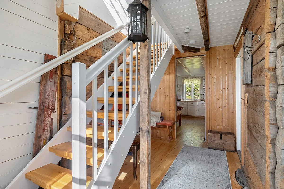 The front hall, and the entrance to the kitchen. The stairs lead up to the second floor bedrooms.