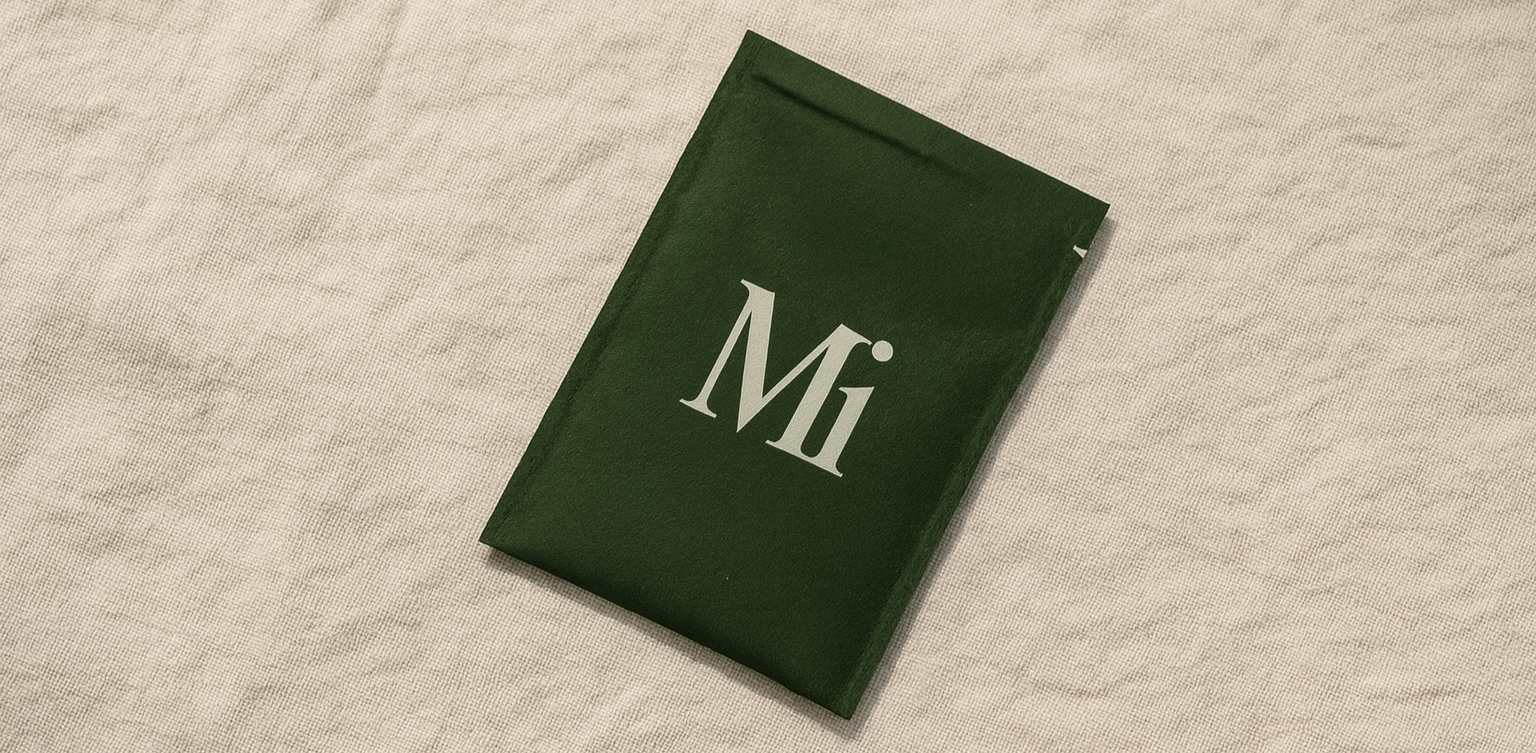 A green book with the title 'Mi' on the cover, placed on a beige textured surface.